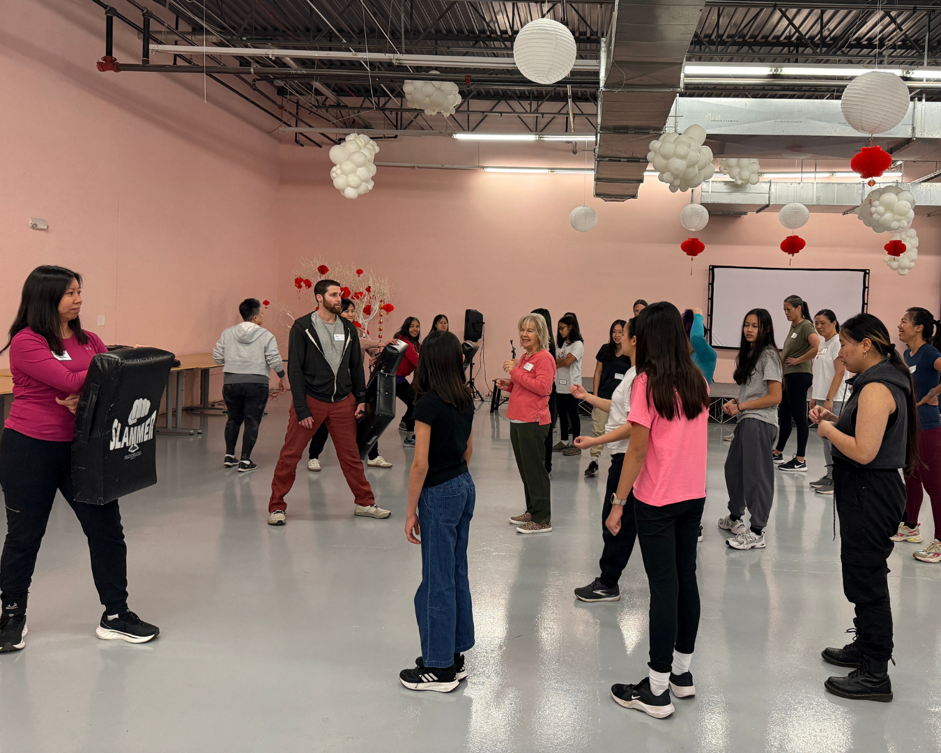 parents stand on left in rows while students line up in each for karate exercise