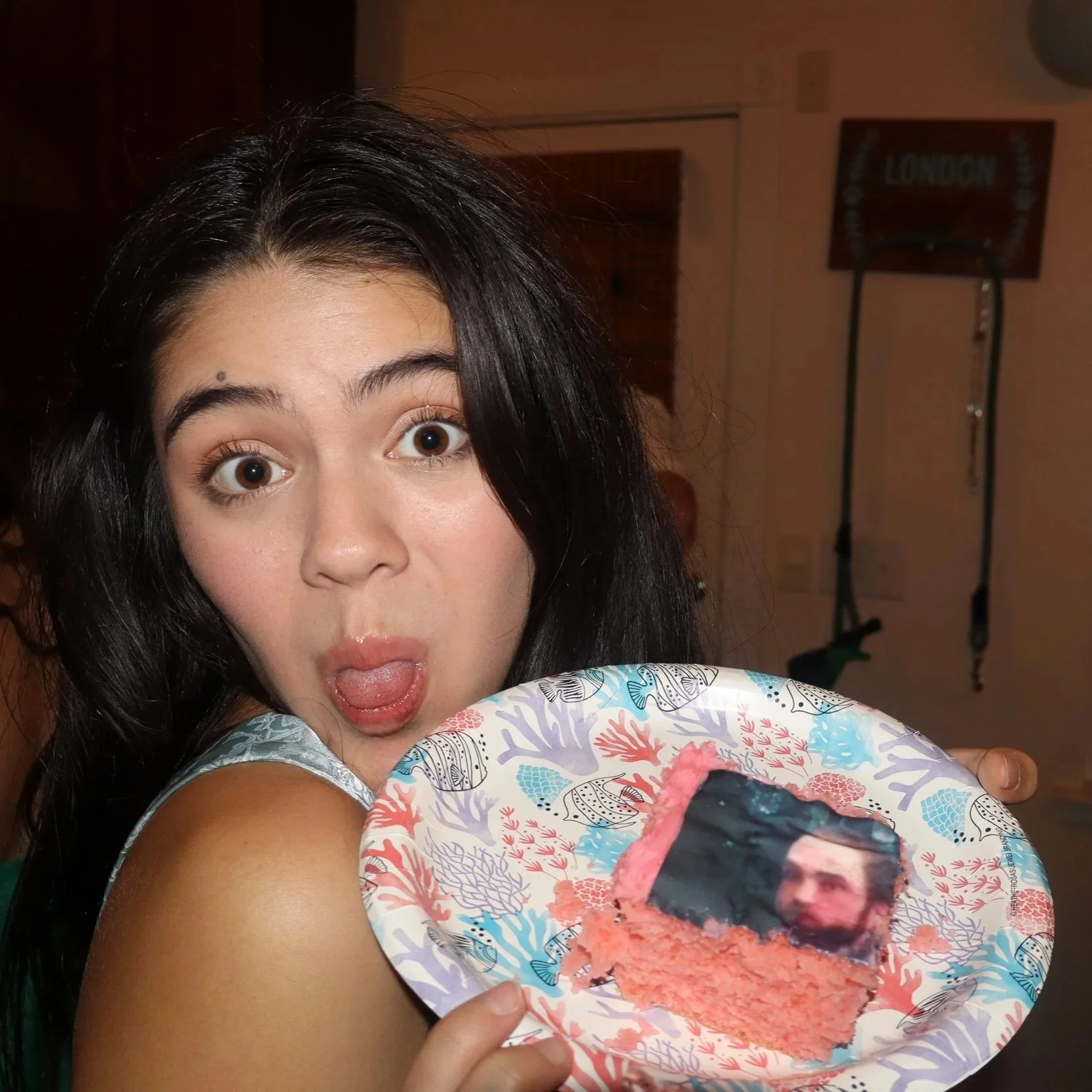 asian american teen holding a cake and sticking her tongue out