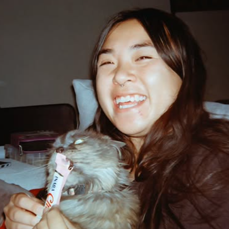 asian american small business owner smiling with their cat