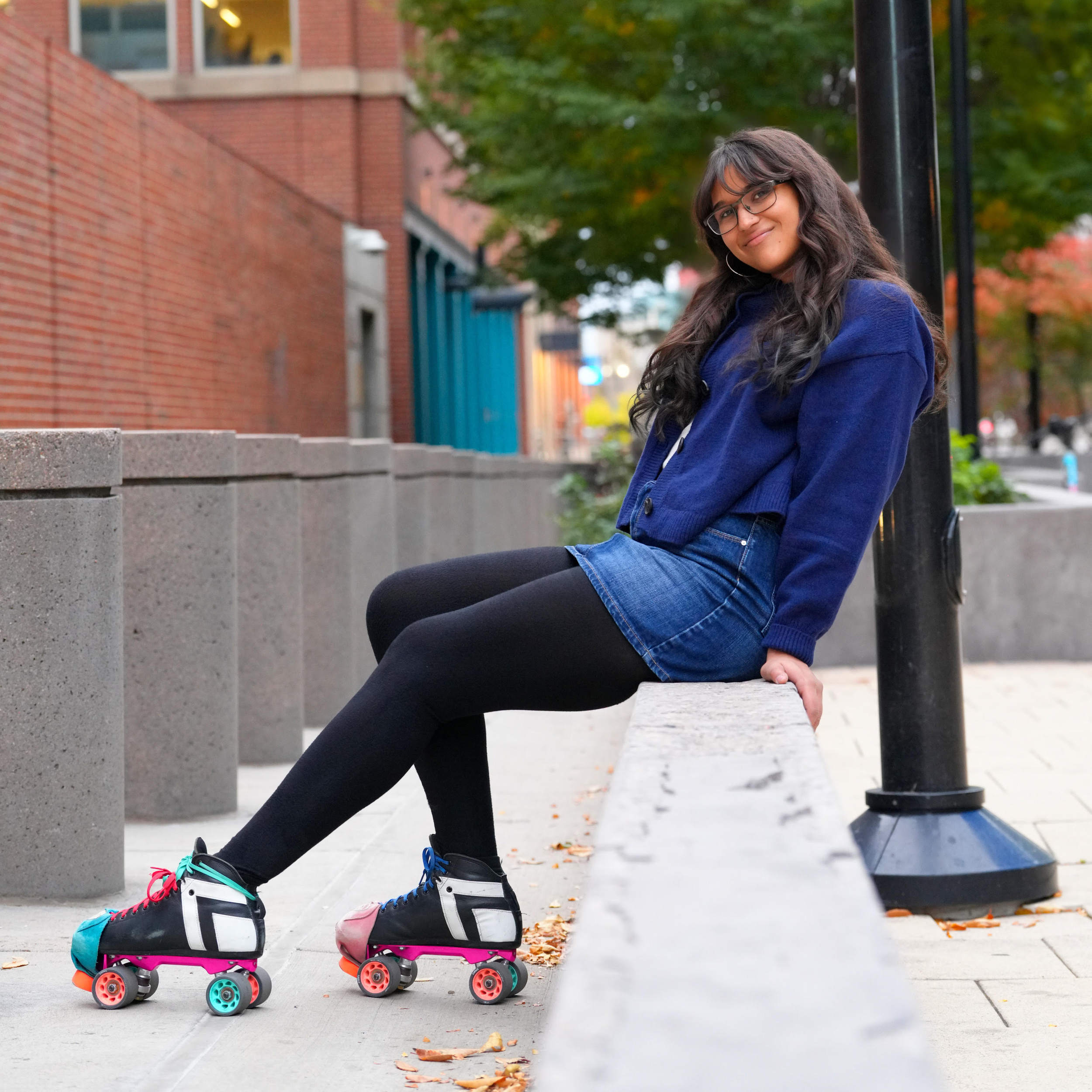 asian american teen posing on ledge with derby skates