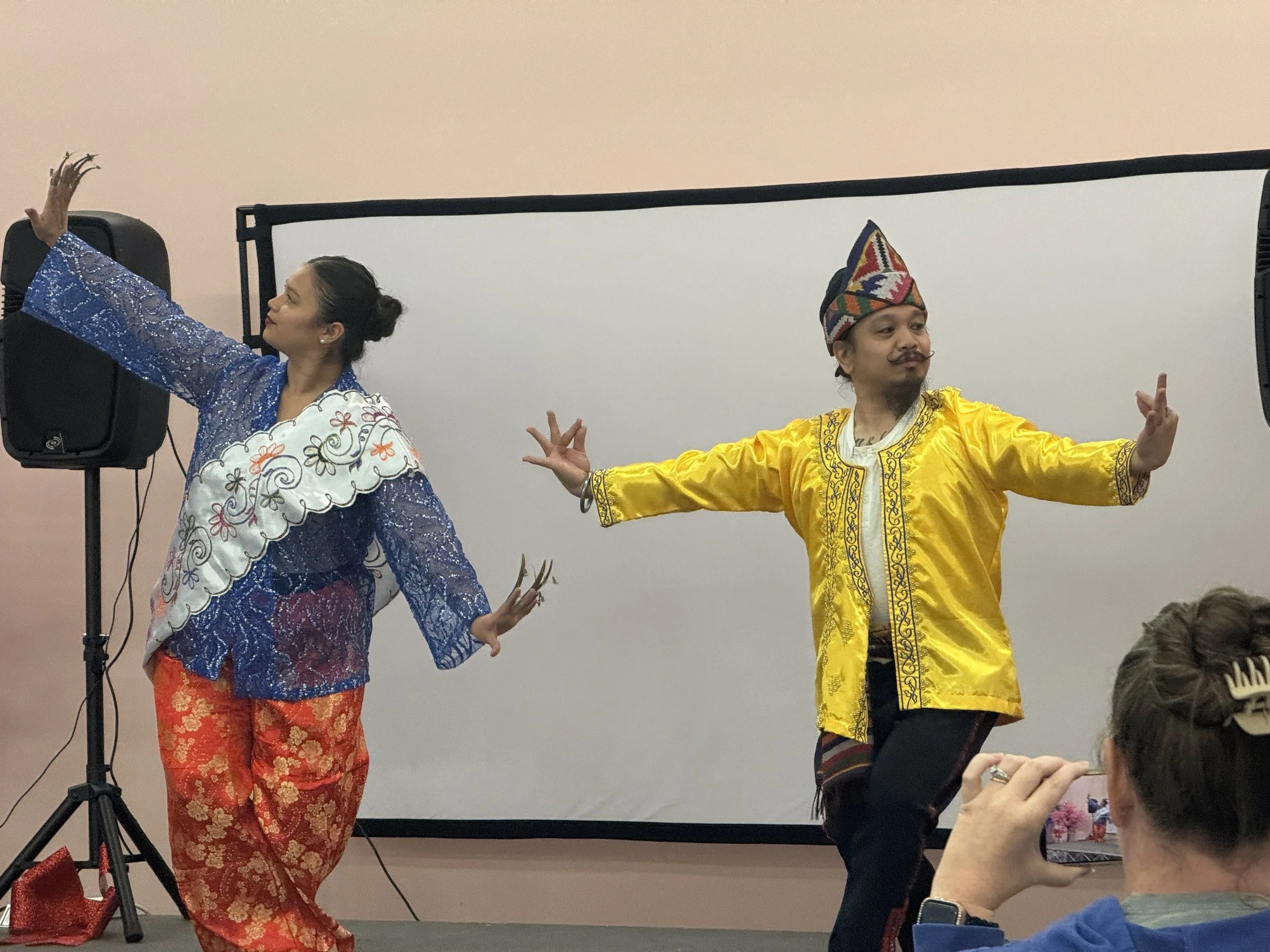 Padayon Cultural FACC perform traditional Filipino Pangalay Janggay on stage in light pink room