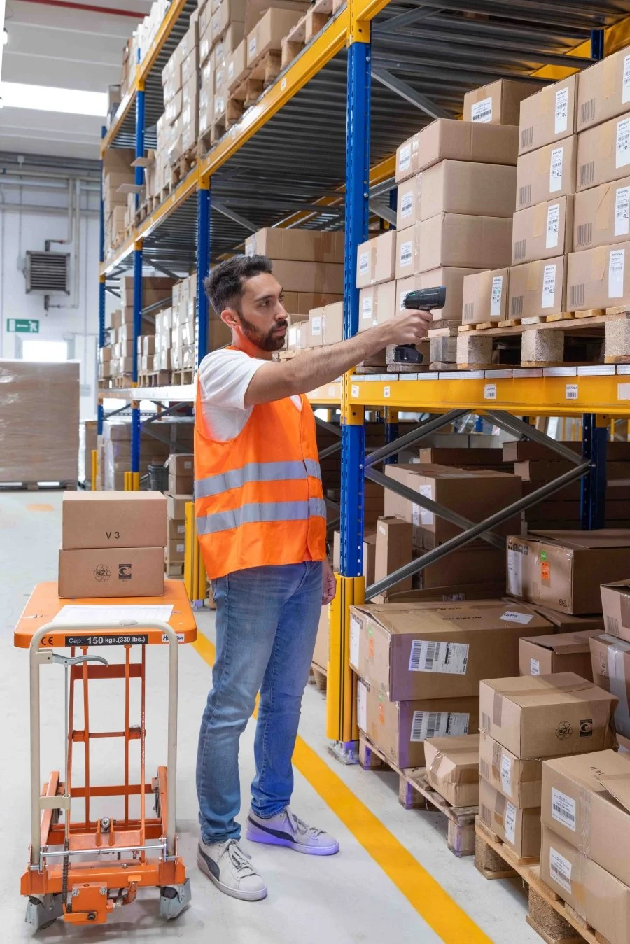man in a warehouse scanning barcodes with a powerscann 9600