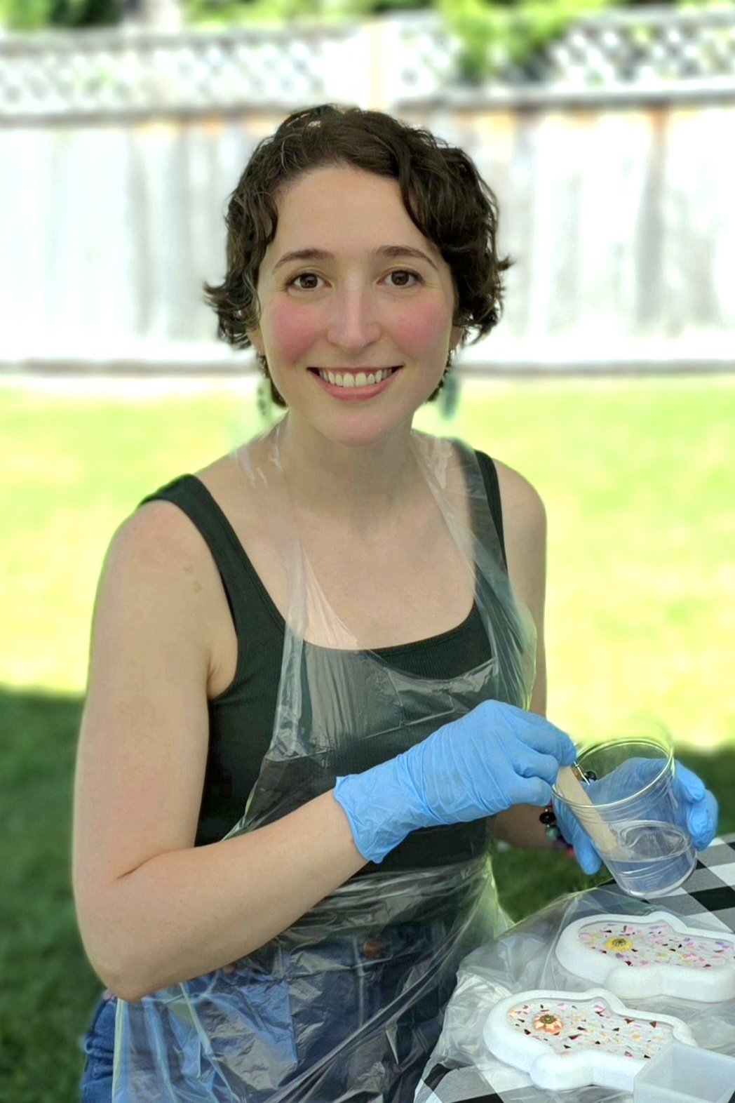 Picture of a friendly, smiling woman with short brown hair doing an art project
