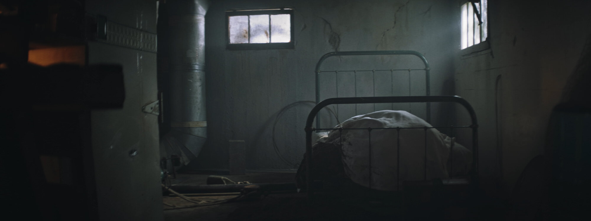 The Altruist - Seemingly empty bed in dark and grungy room