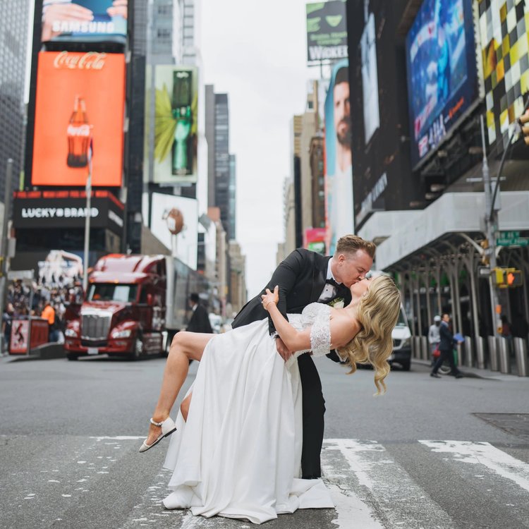Groom dipping his bride for a kiss on a Times Square crosswalk
