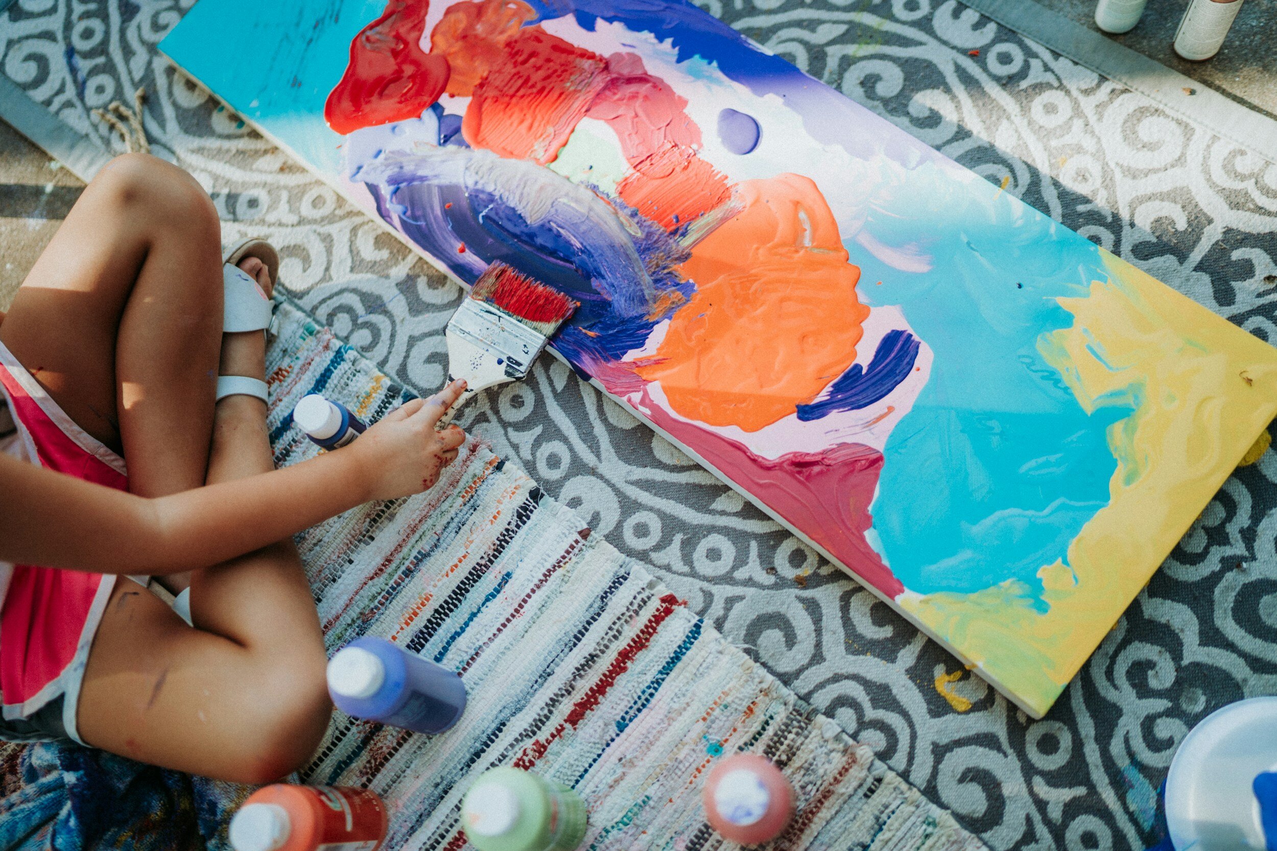 A painter expressing themselves creatively by painting abstract art.