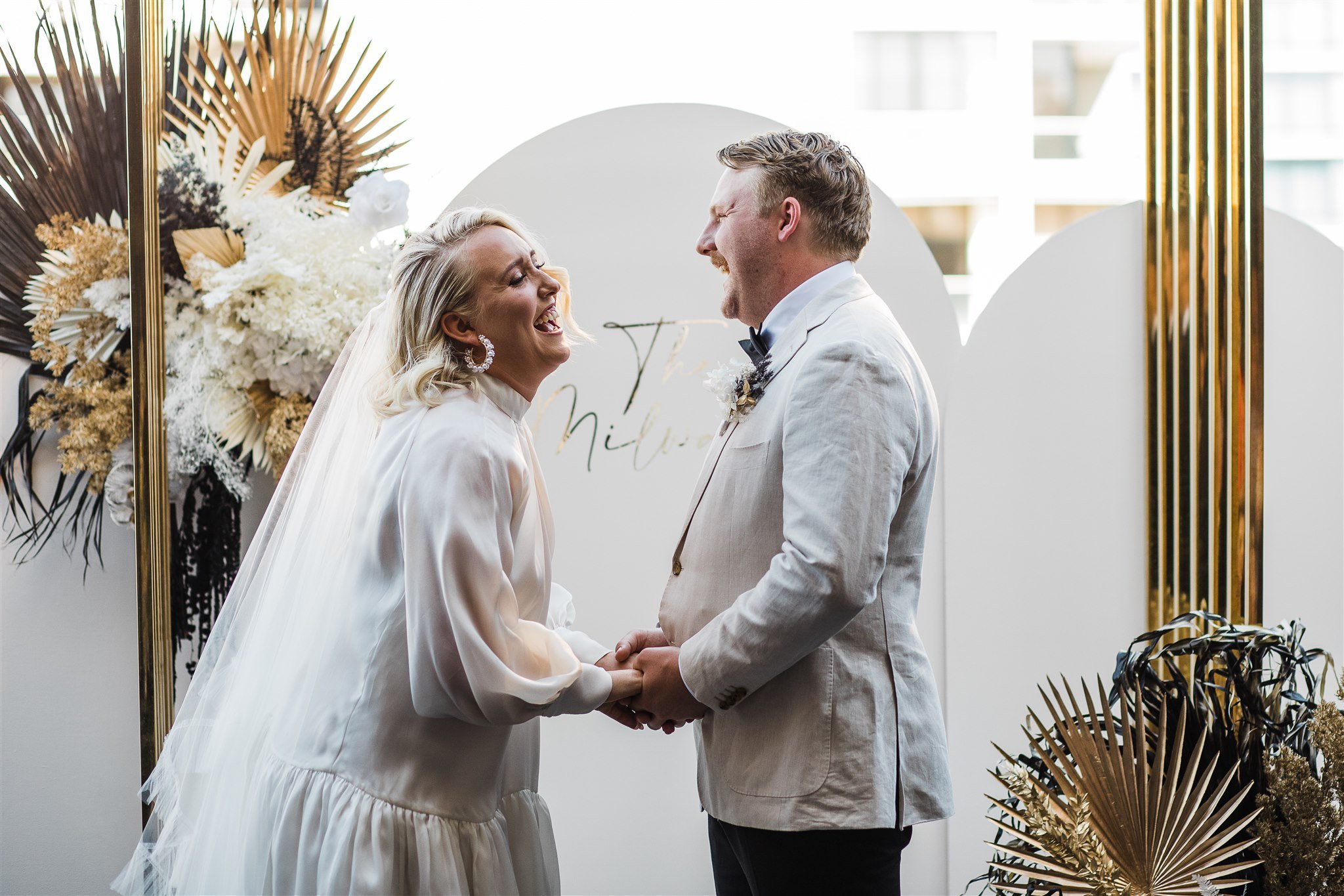  the couple laughing and holding hands while saying their vows at their wedding in Aurora Rooftop Melbourne Hotel 