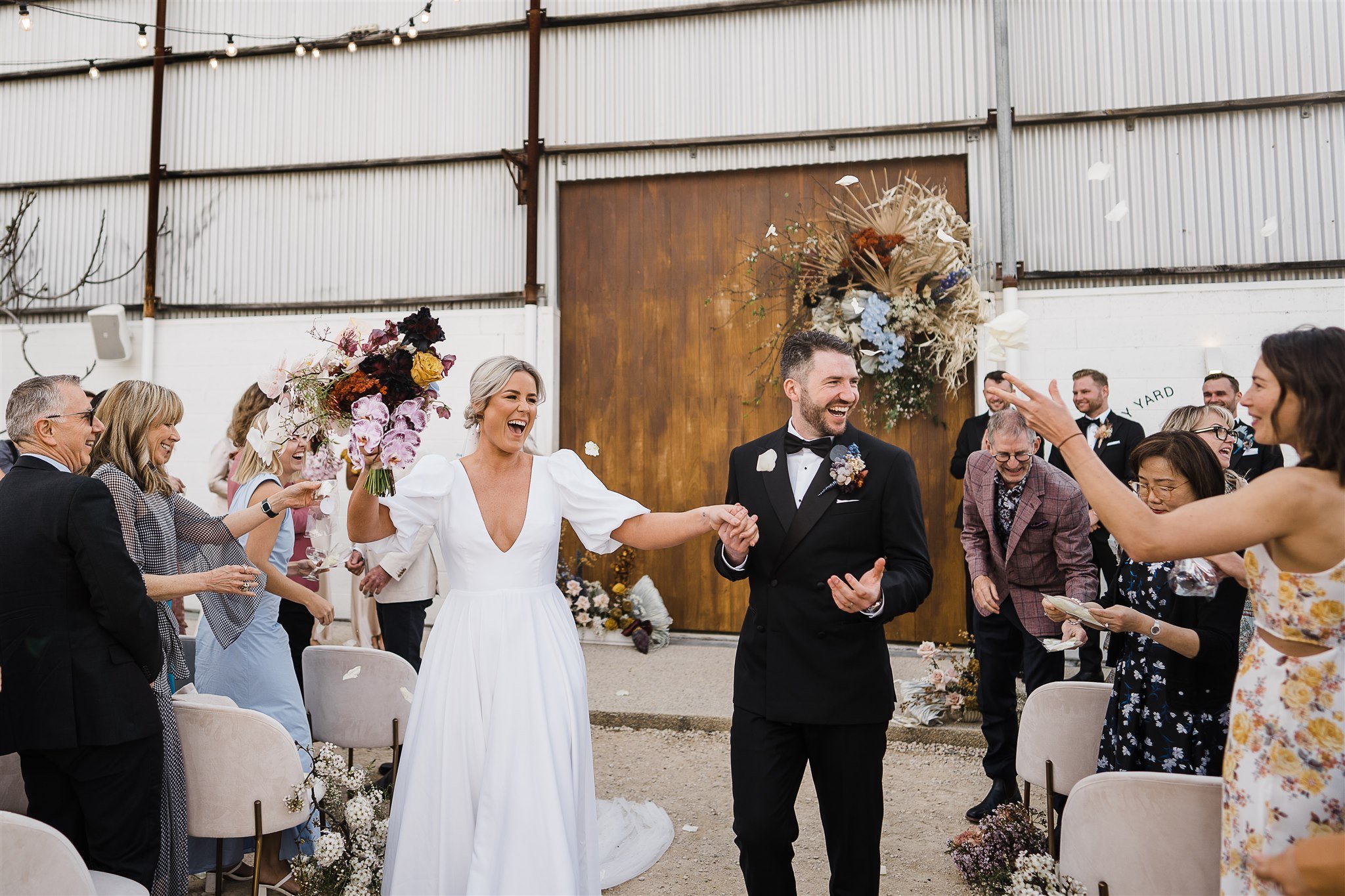  a happy newly wed couple exiting after their wedding in Assembly Yard, Fermantle Australia 