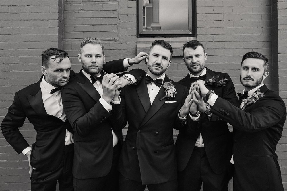 the groom and his groomsmen having a silly pose at the wedding in Assembly Yard, Fermantle Australia 