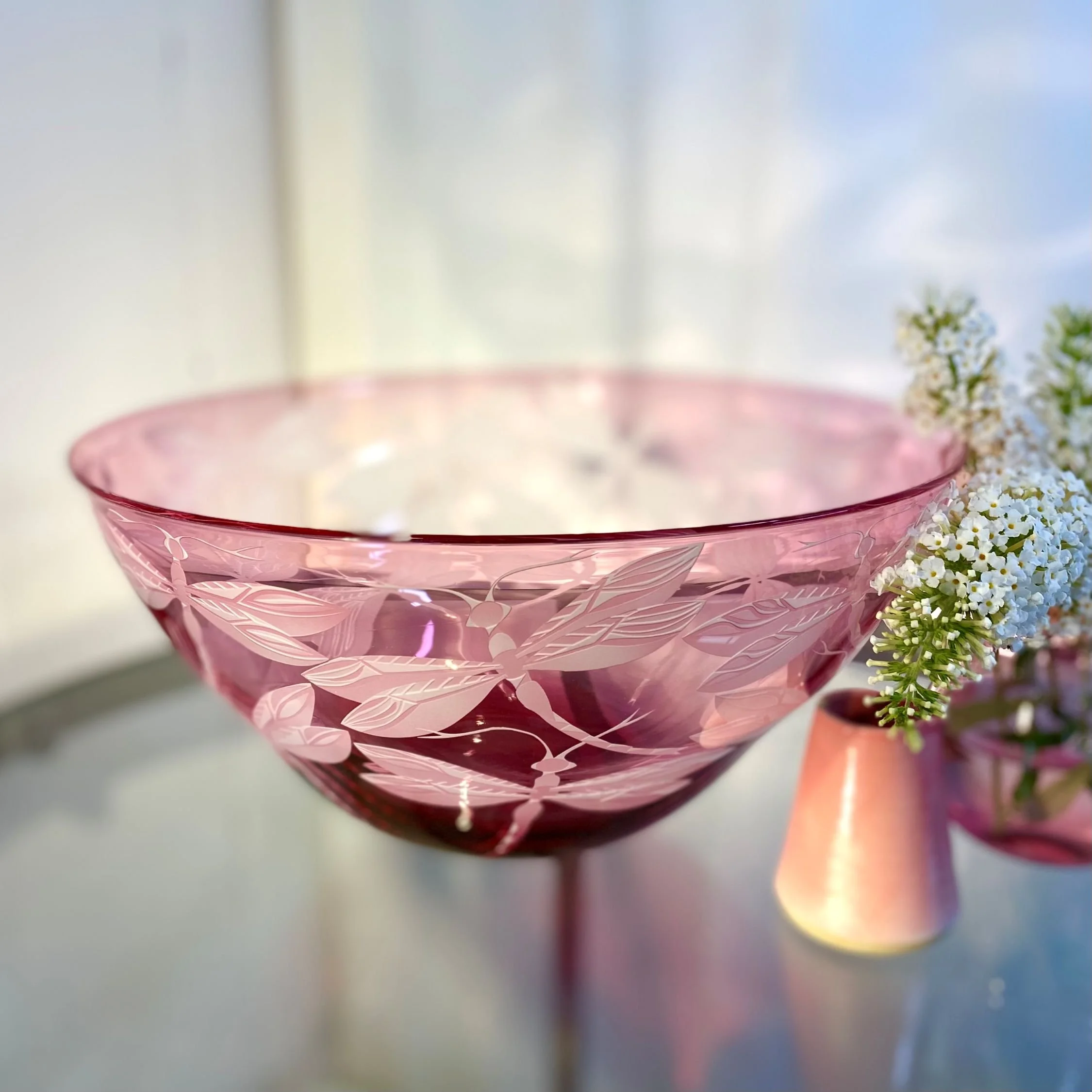 A pink bowl decorated with dragonflies by Julia Linstead, Glass