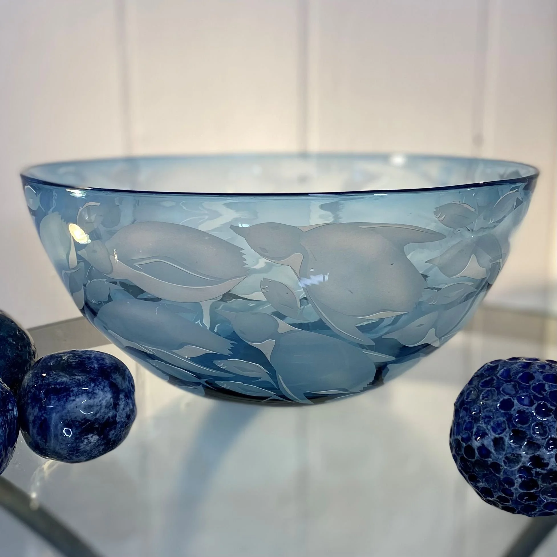 Steel blue crystal bowl decorated with penguins amongst fish by Julia Linstead, Glass