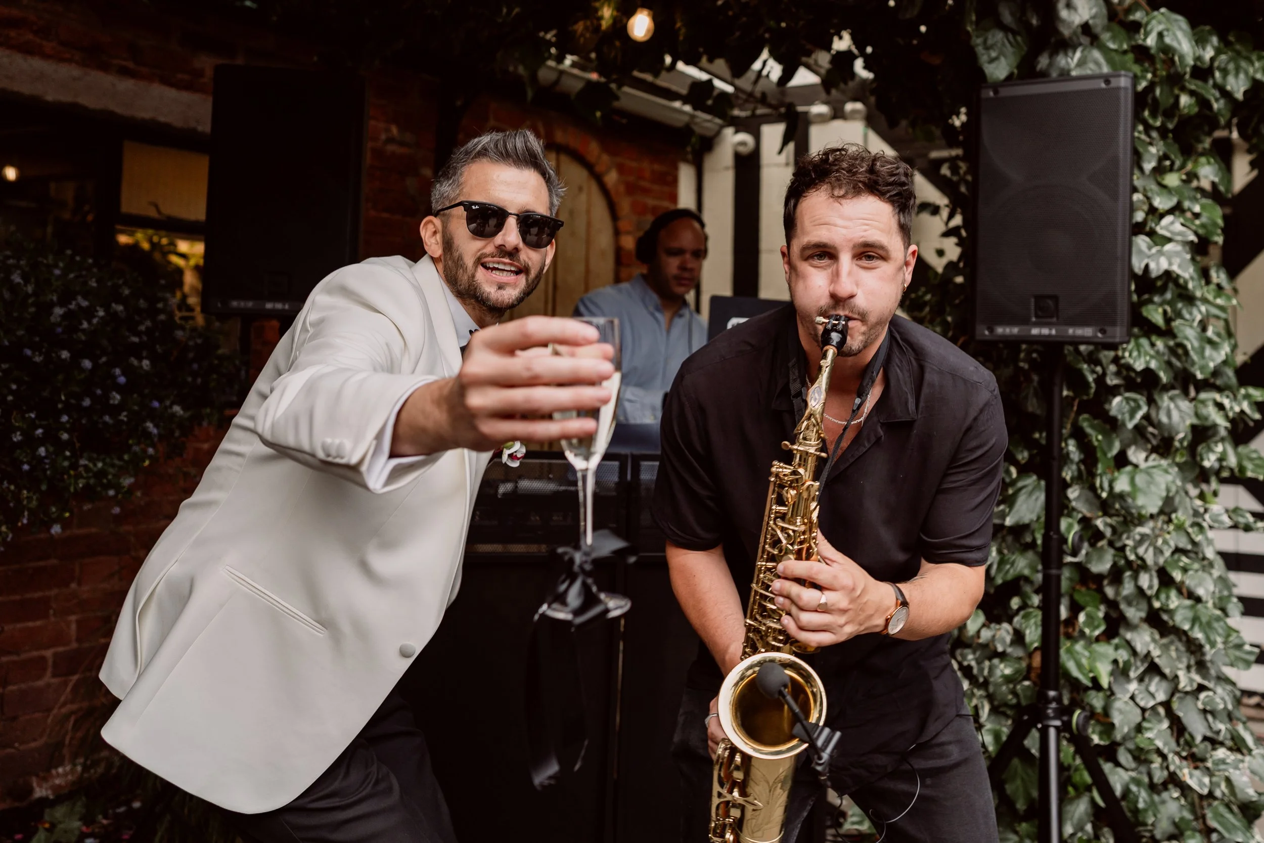 Groom dancing with saxophonist on wedding day at Shack Revolution