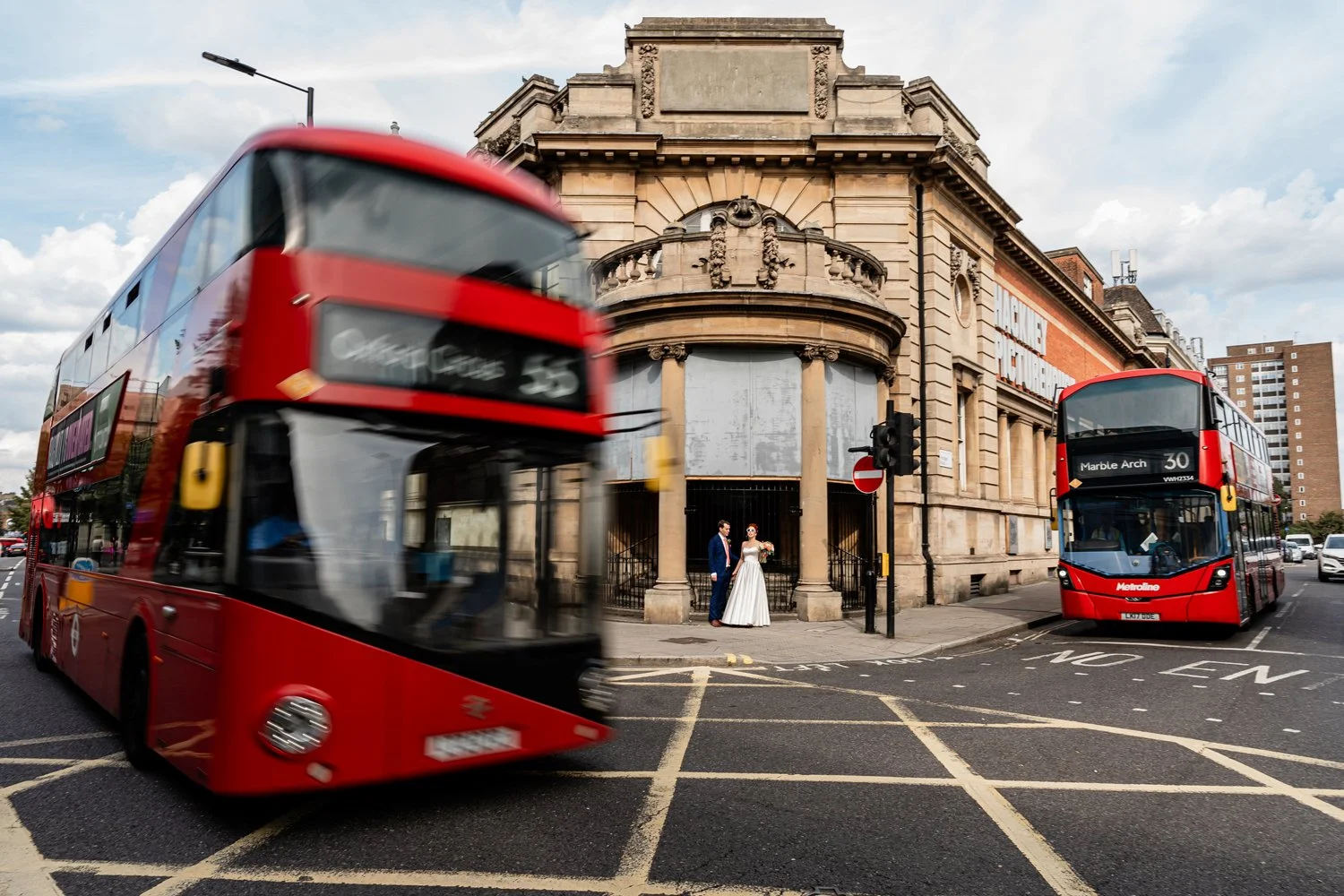 Bride and groom standing outside Hackney picture house on their wedding day in London