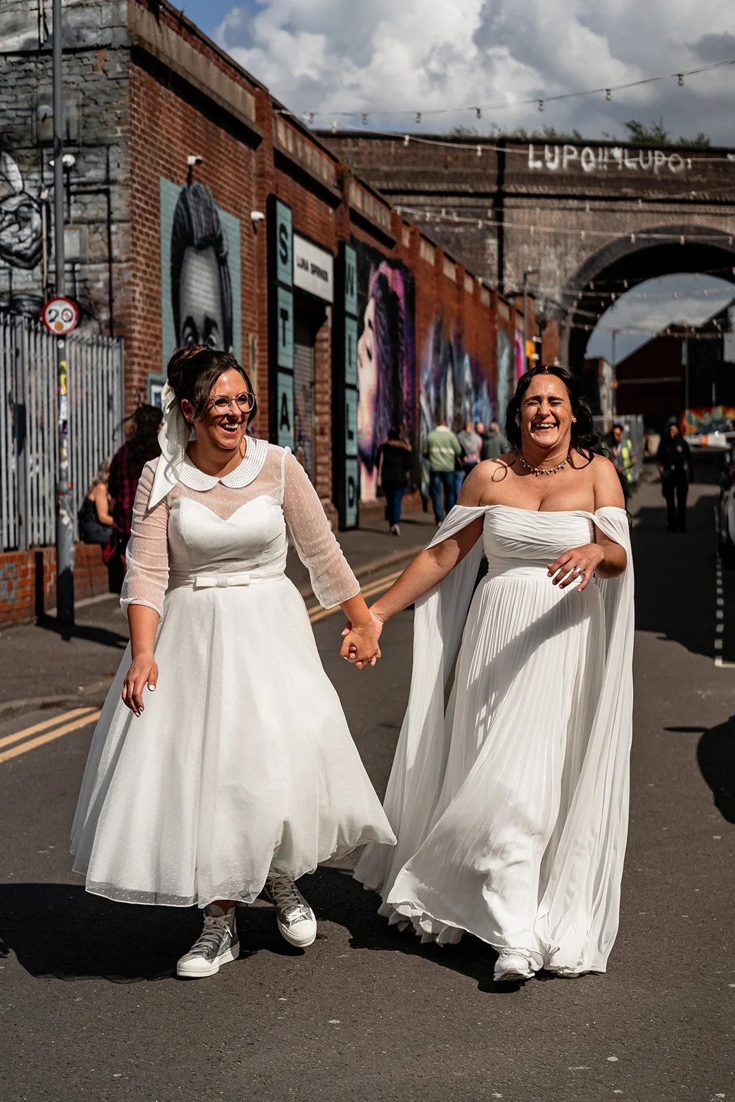 brides walking and laughing on their inclusive wedding day