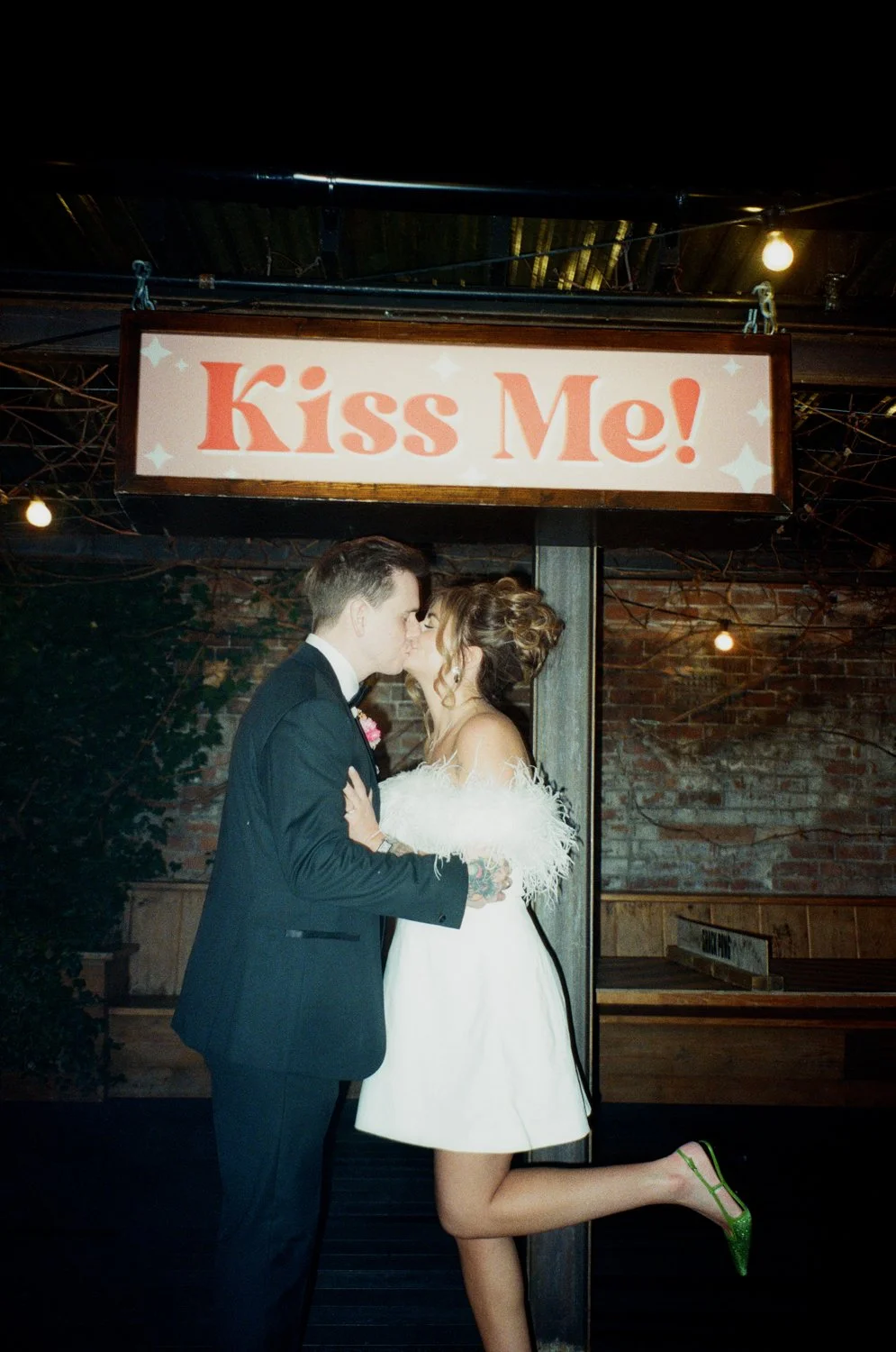 Bride and groom kissing under sign captured on film by Birmingham wedding photographer