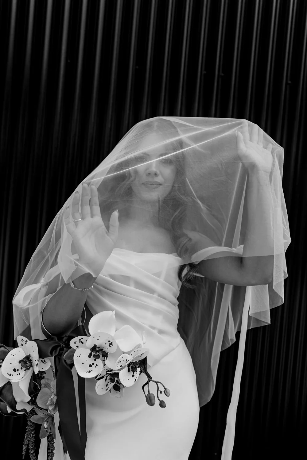 Bride posing under her veil on wedding day at Alternative venue