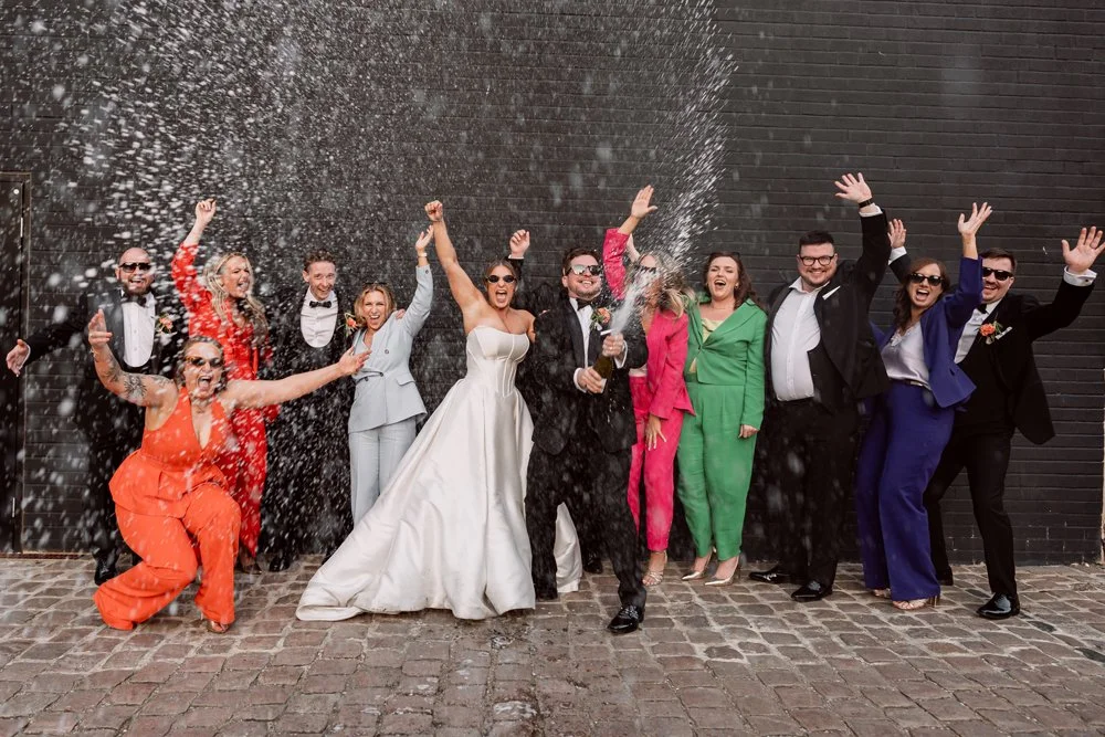 Bride and groom doing a prosecco spray with their friends on their wedding day at The Bond in Digbeth