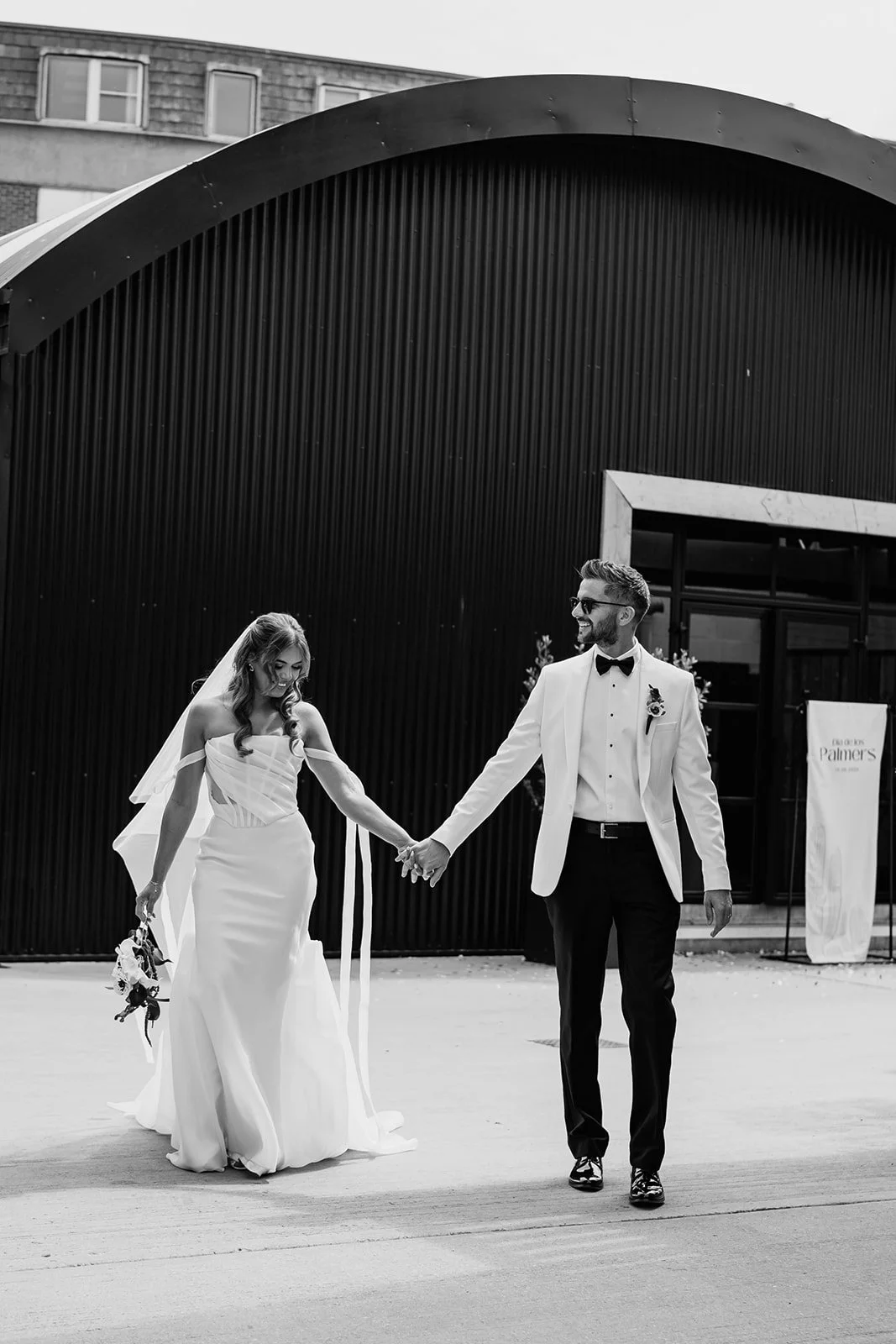 A black and white candid portrait of couple holding hands during Birmingham wedding
