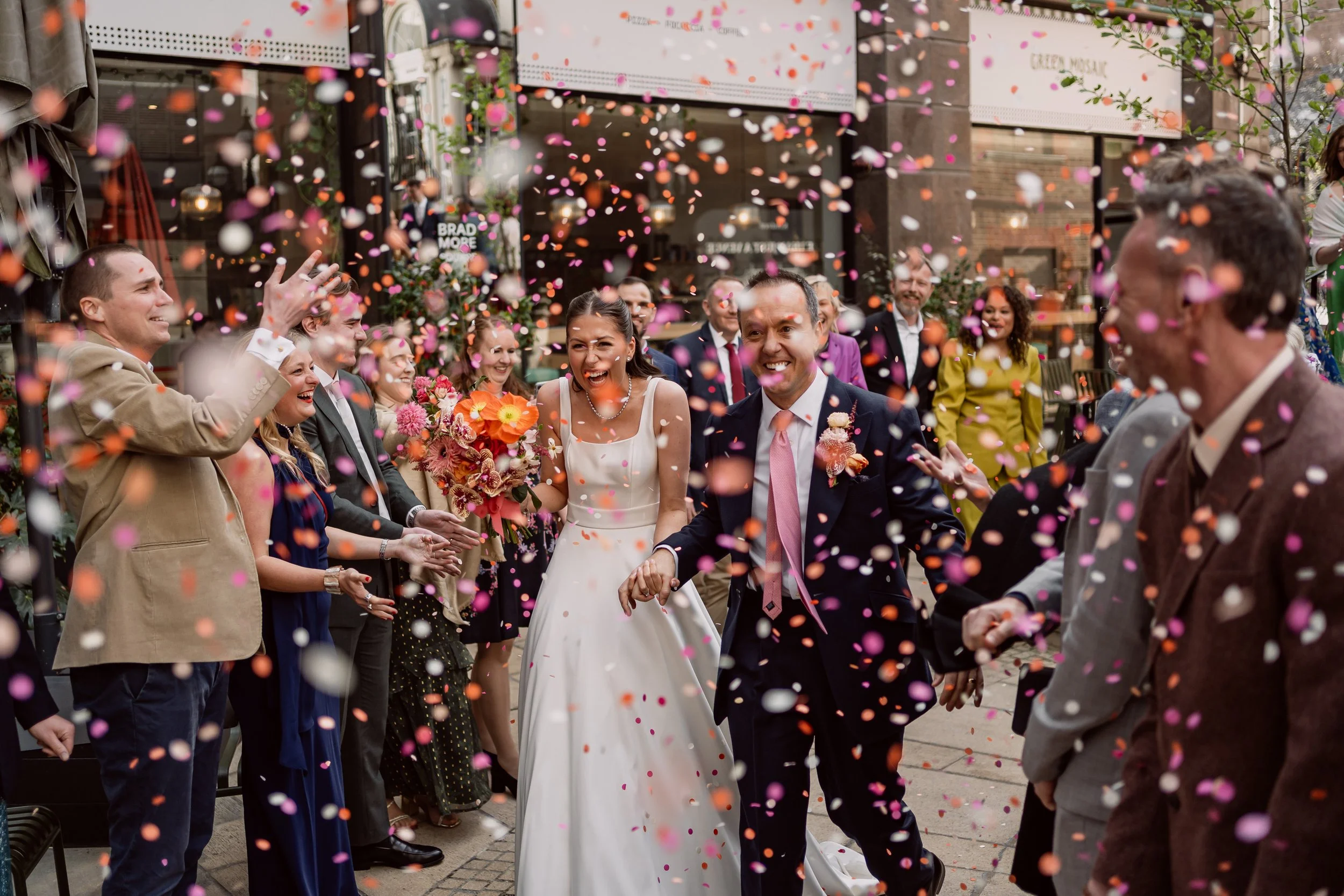 Bride and groom walking through confetti on their wedding day at Kindred in Hammersmith