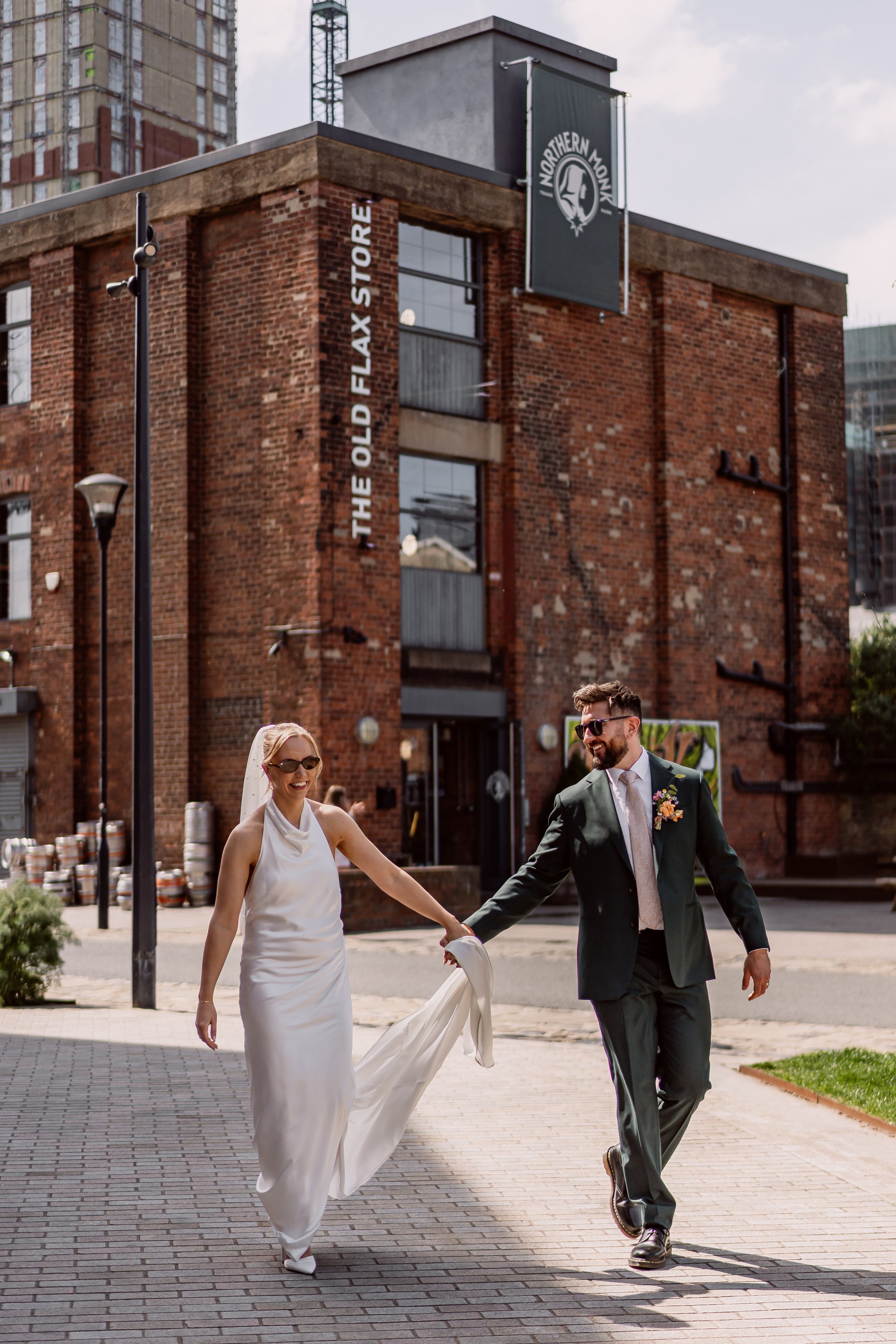 Bride and groom laughing and walking outside Northern Monk Refectory