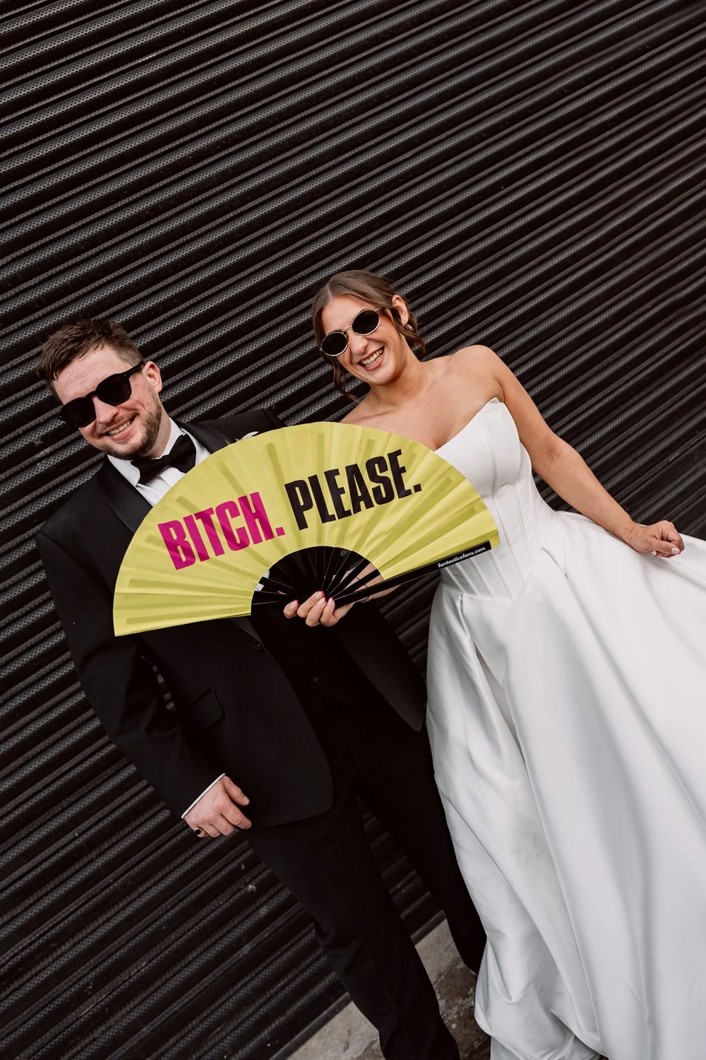 Bride and groom laughing as bride hold a big fan on their wedding day in Digbeth