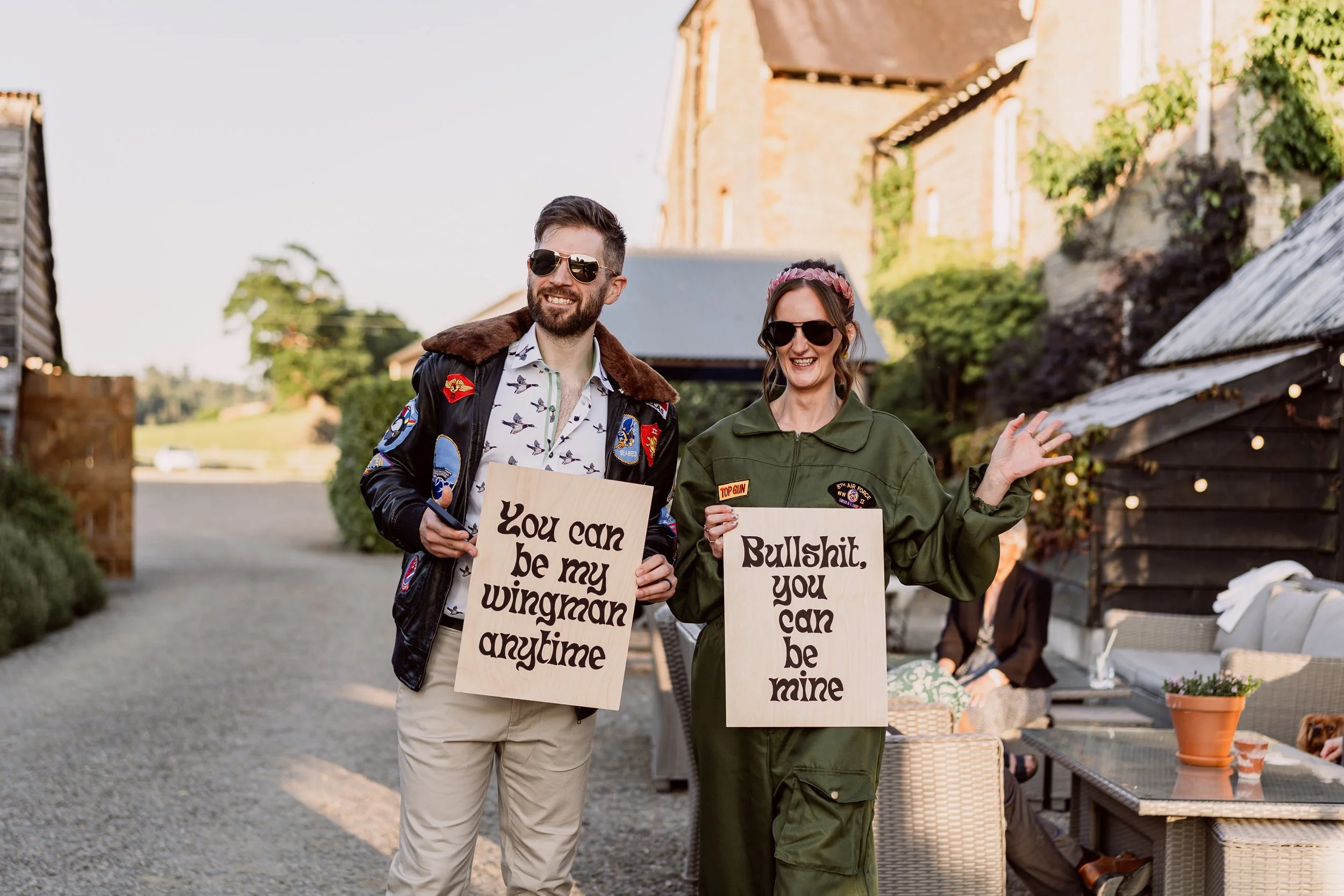 The bride and groom holding signs at their non-traditional wedding