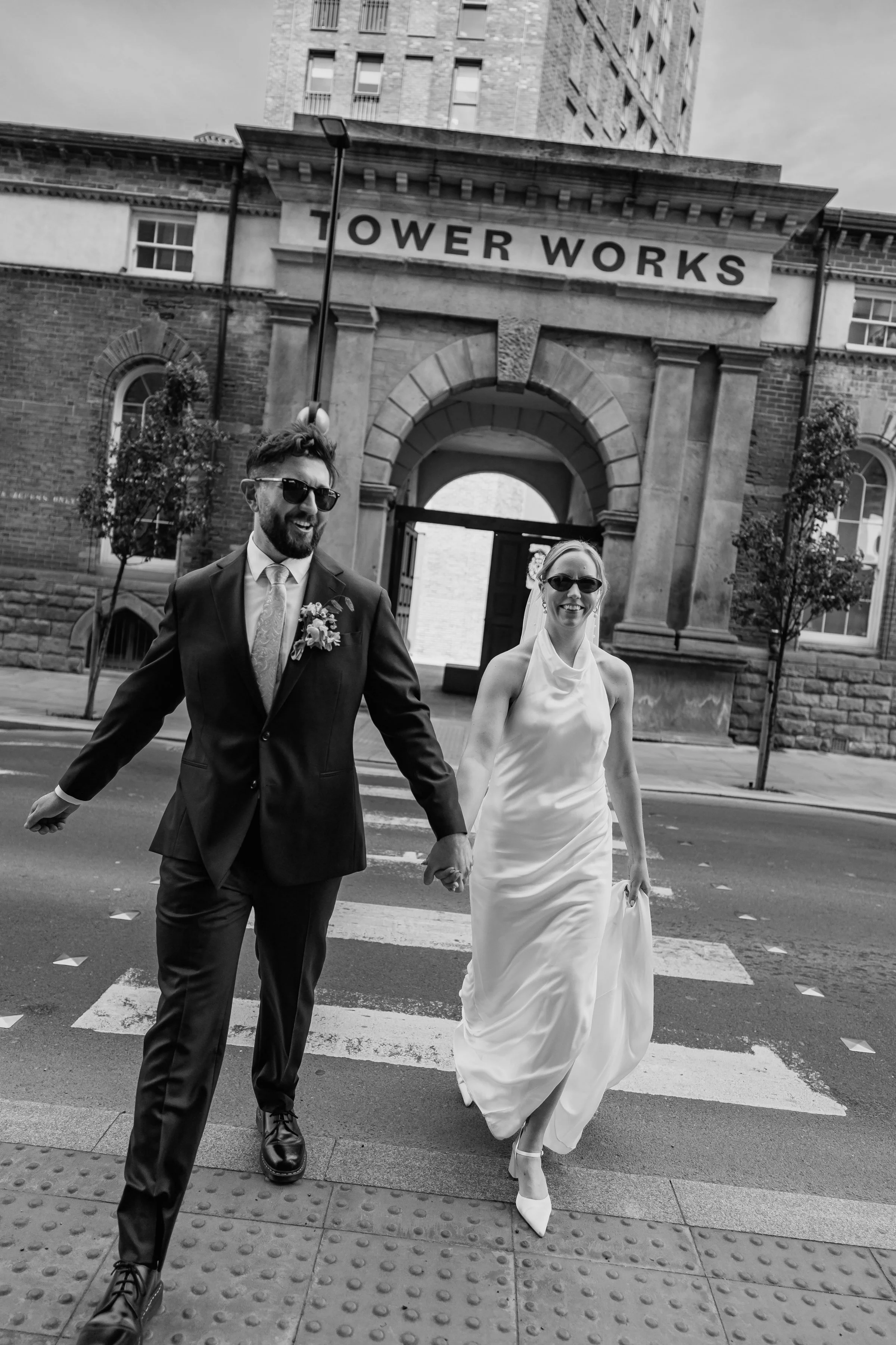 bride and groom crossing road on their wedding day in Leeds