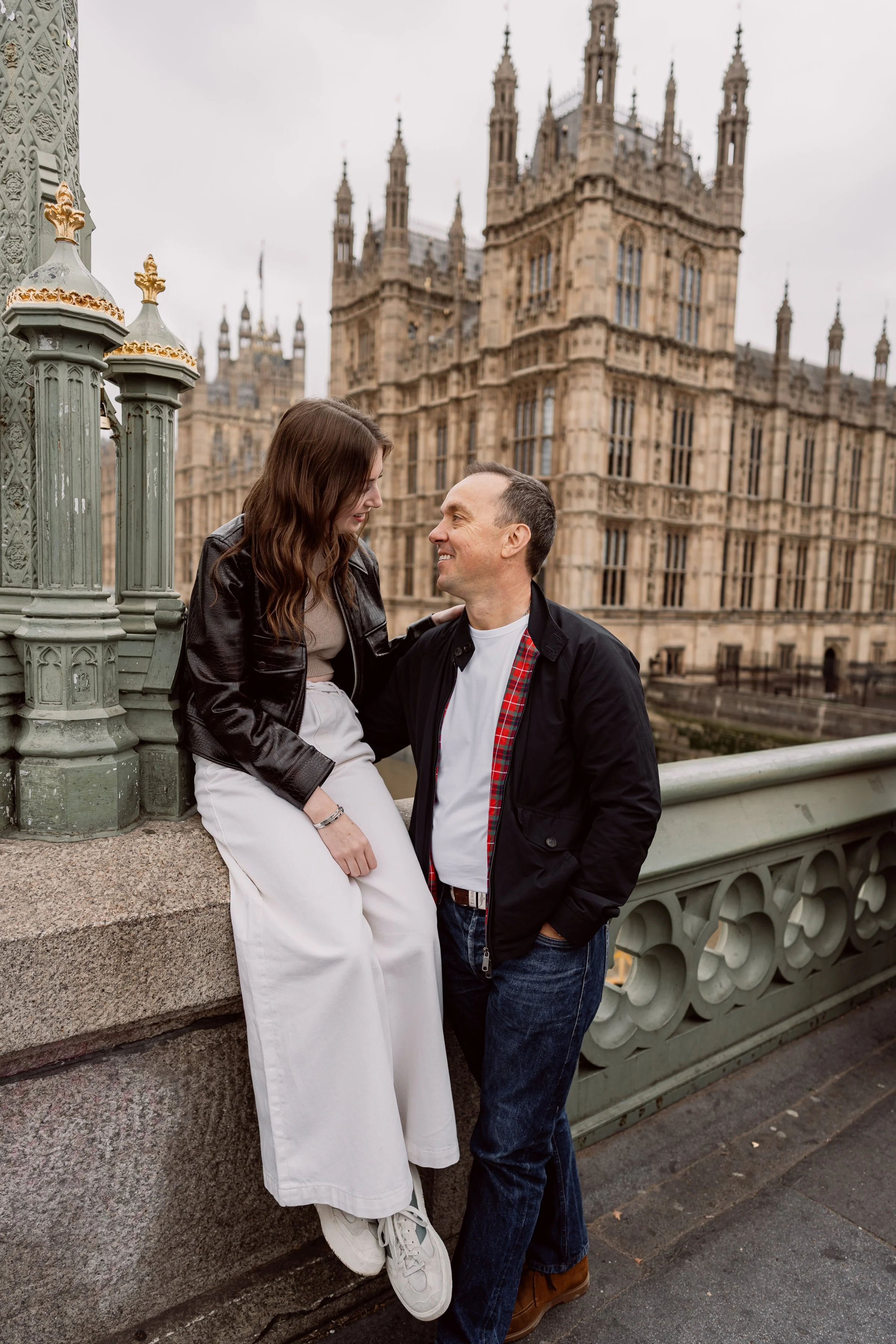 couple on bridge outside parliament on the river thames in London