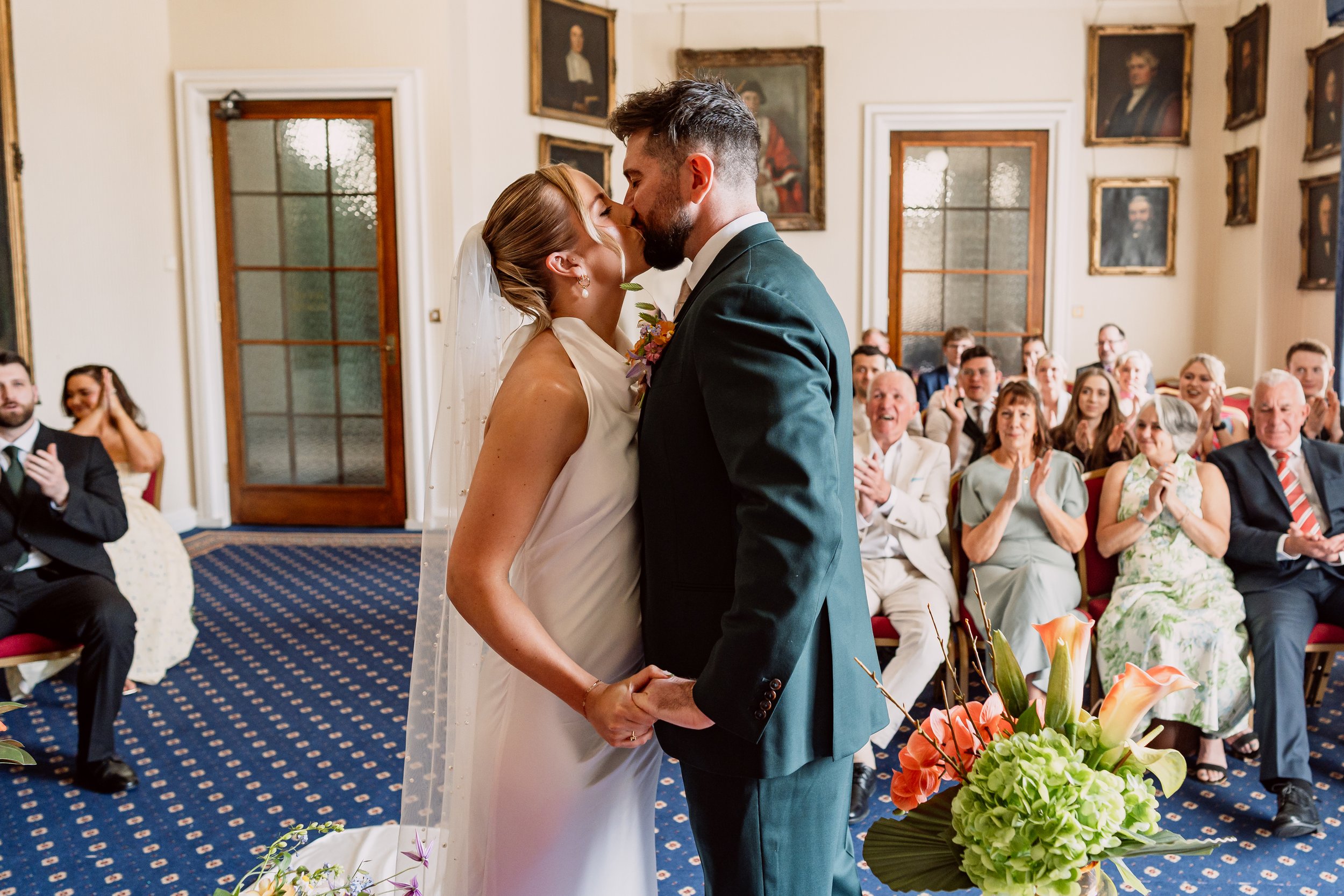 Bride and groom kissing as they say I Do at Leeds Town Hall