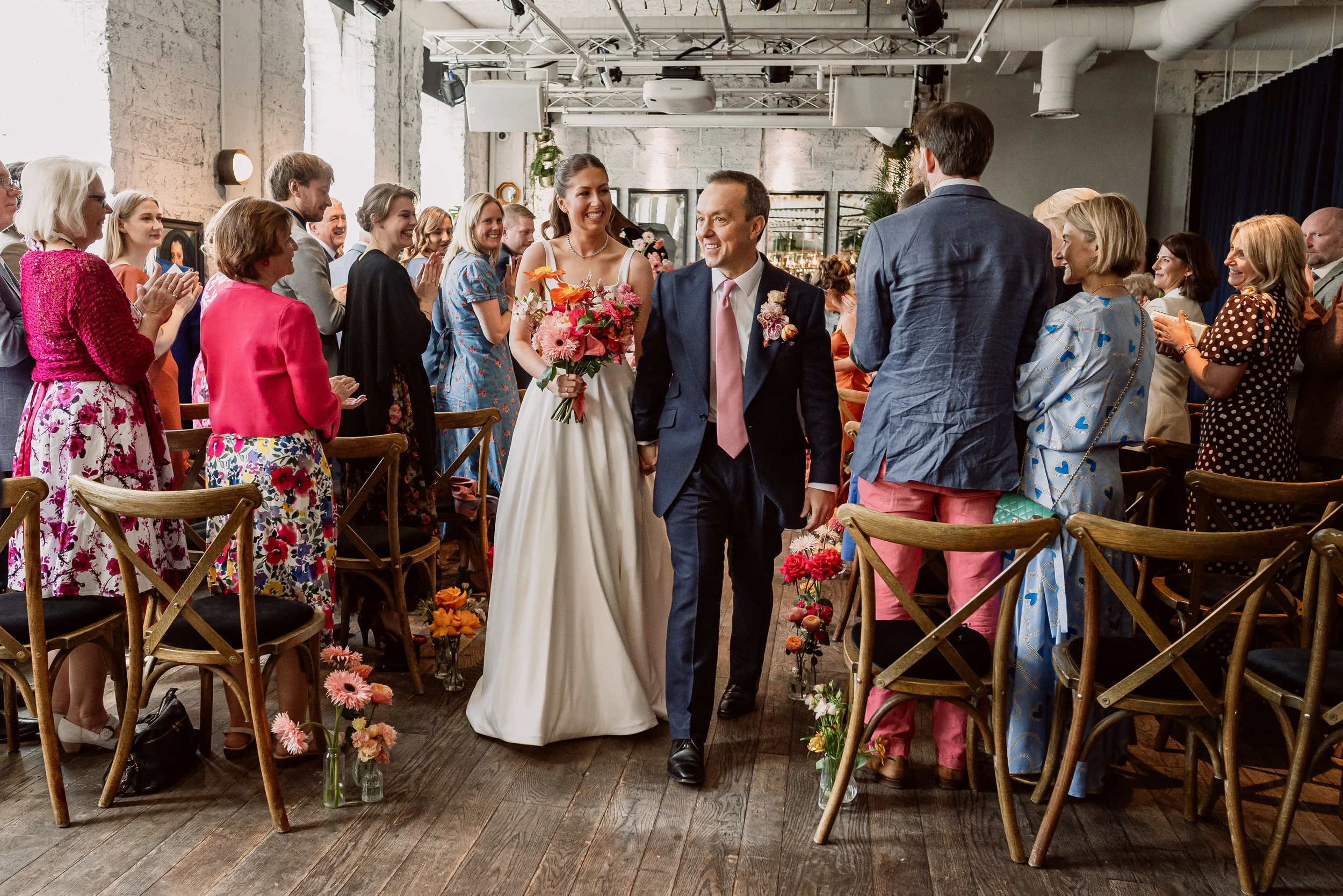 Bride and groom walking up the aisle after getting married at Kindred in Hammersmith