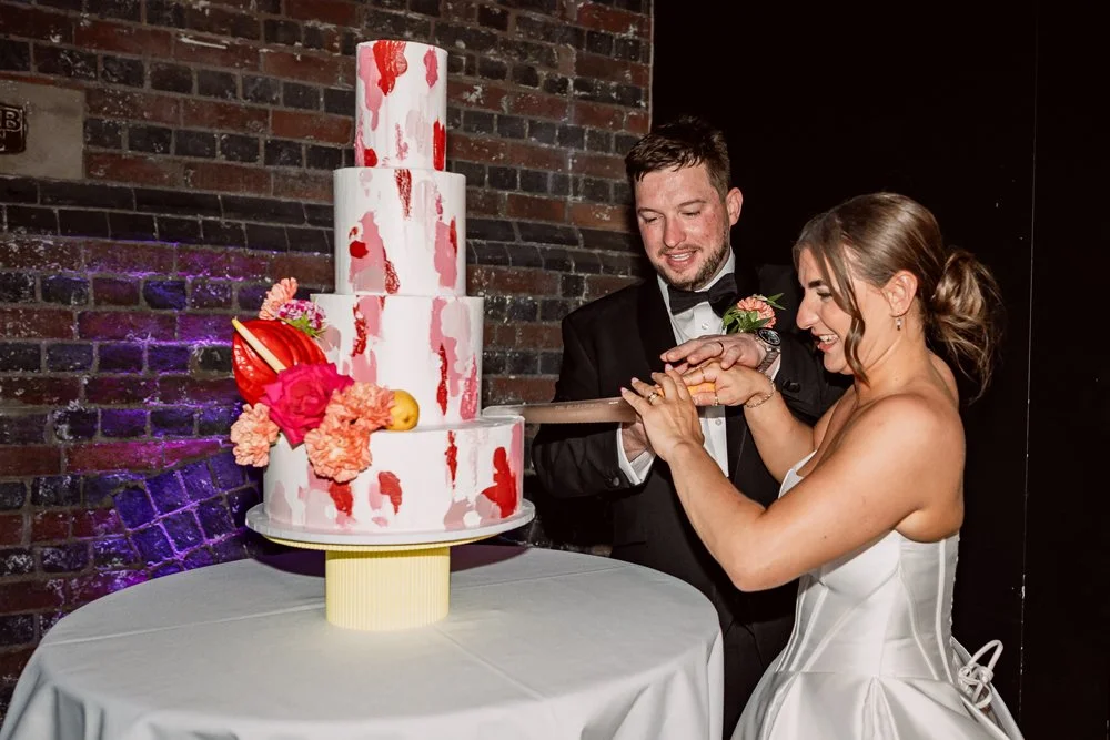 Bride and groom cutting wedding cake on their wedding day in Birmingham