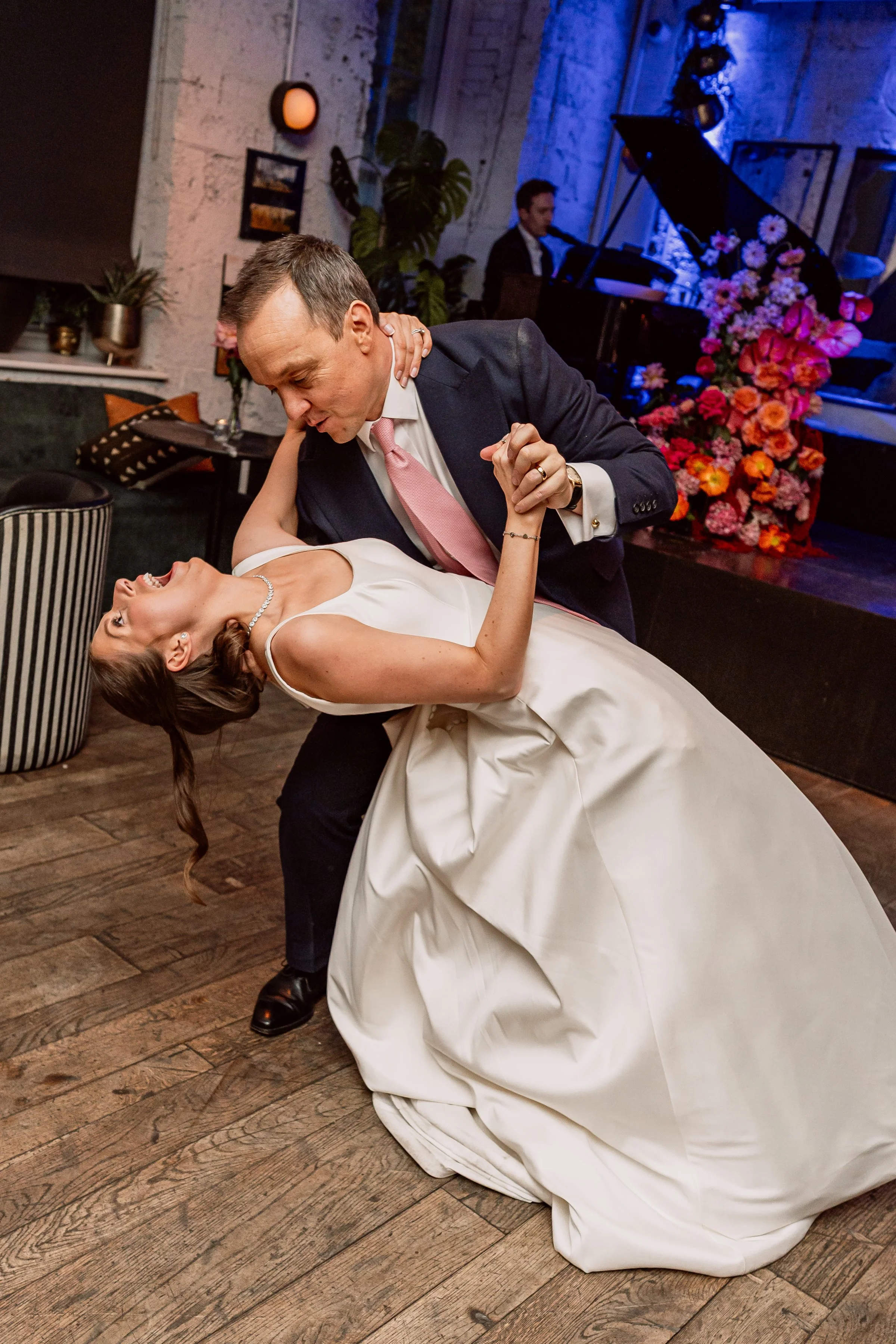 Groom dipping bride during first dance eon wedding day in London
