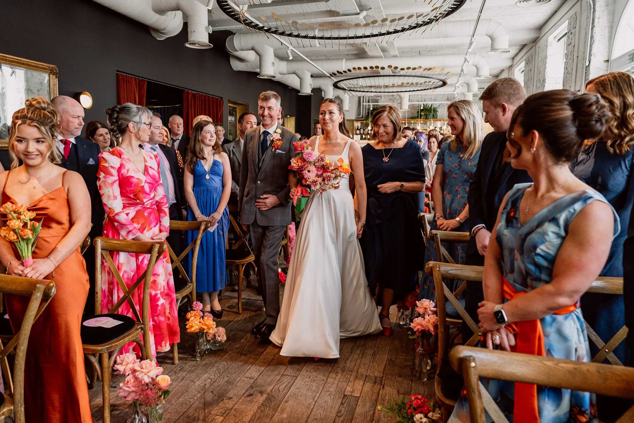 Bride walking down the aisle with her parents on her wedding day at Kindred London
