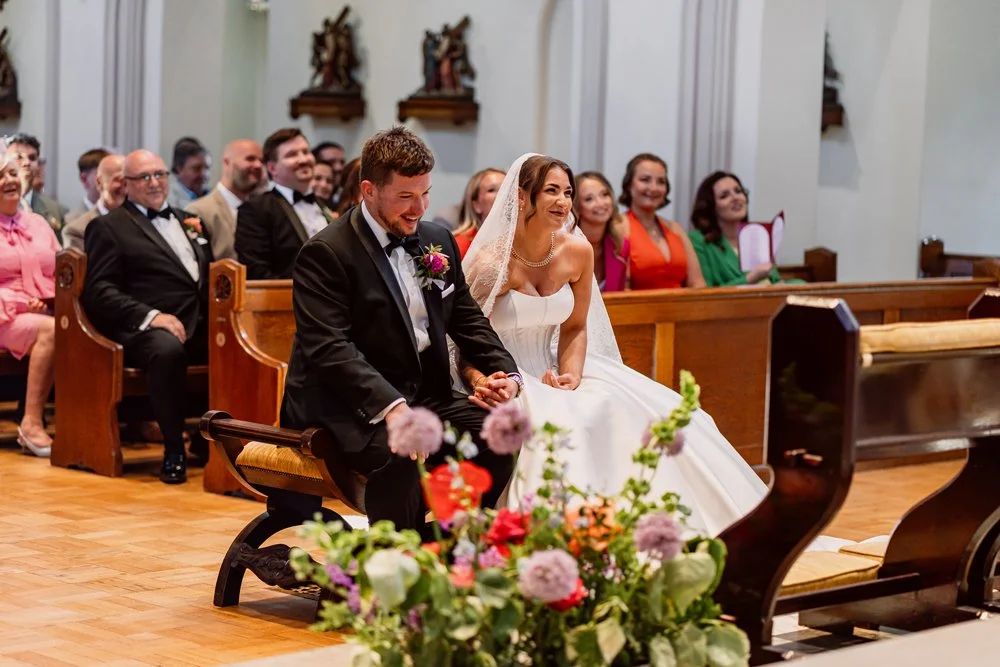 Bride and groom sat smiling during their wedding ceremony in Sutton Coldfield