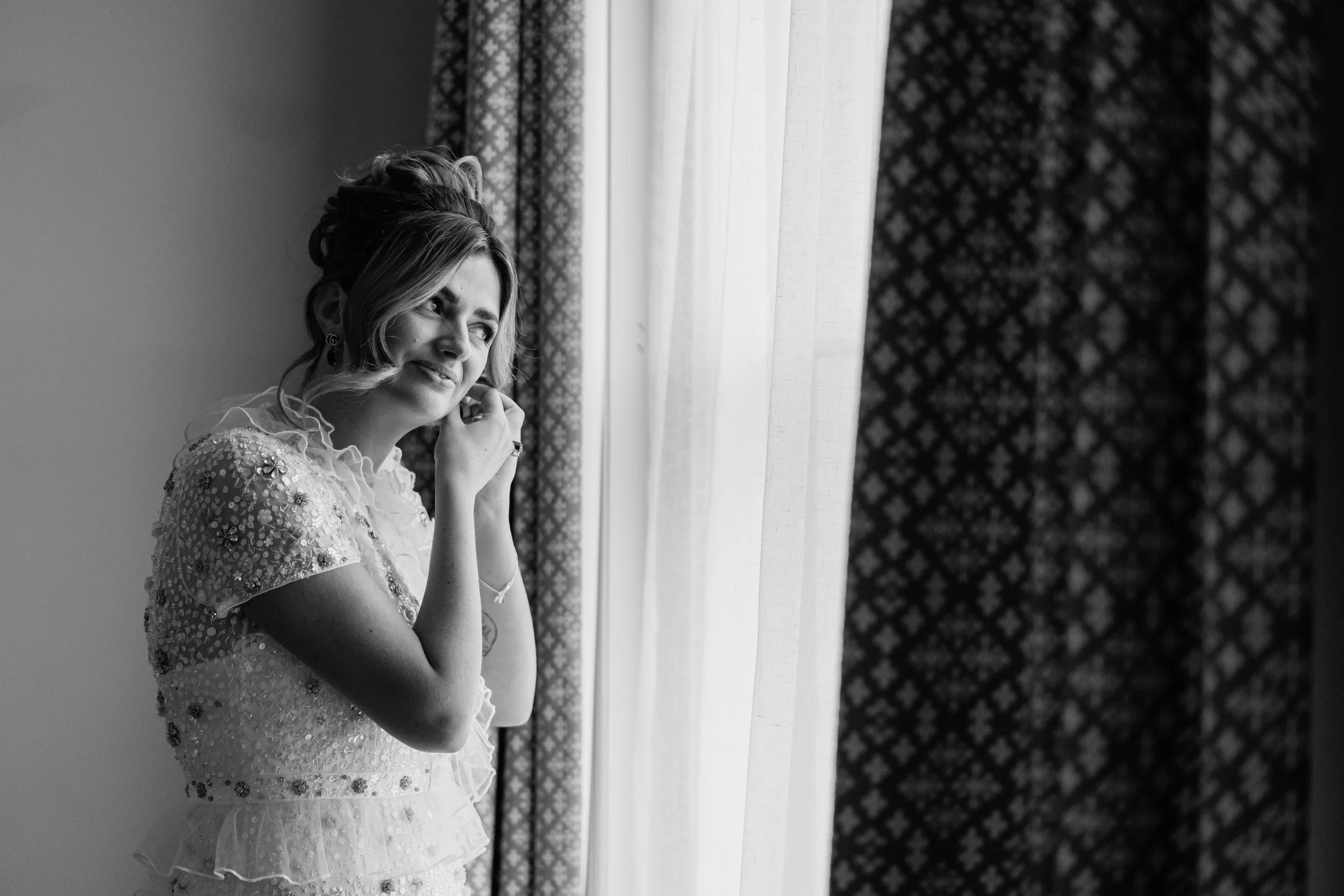 Bride putting on her earring on her wedding morning in Birmingham