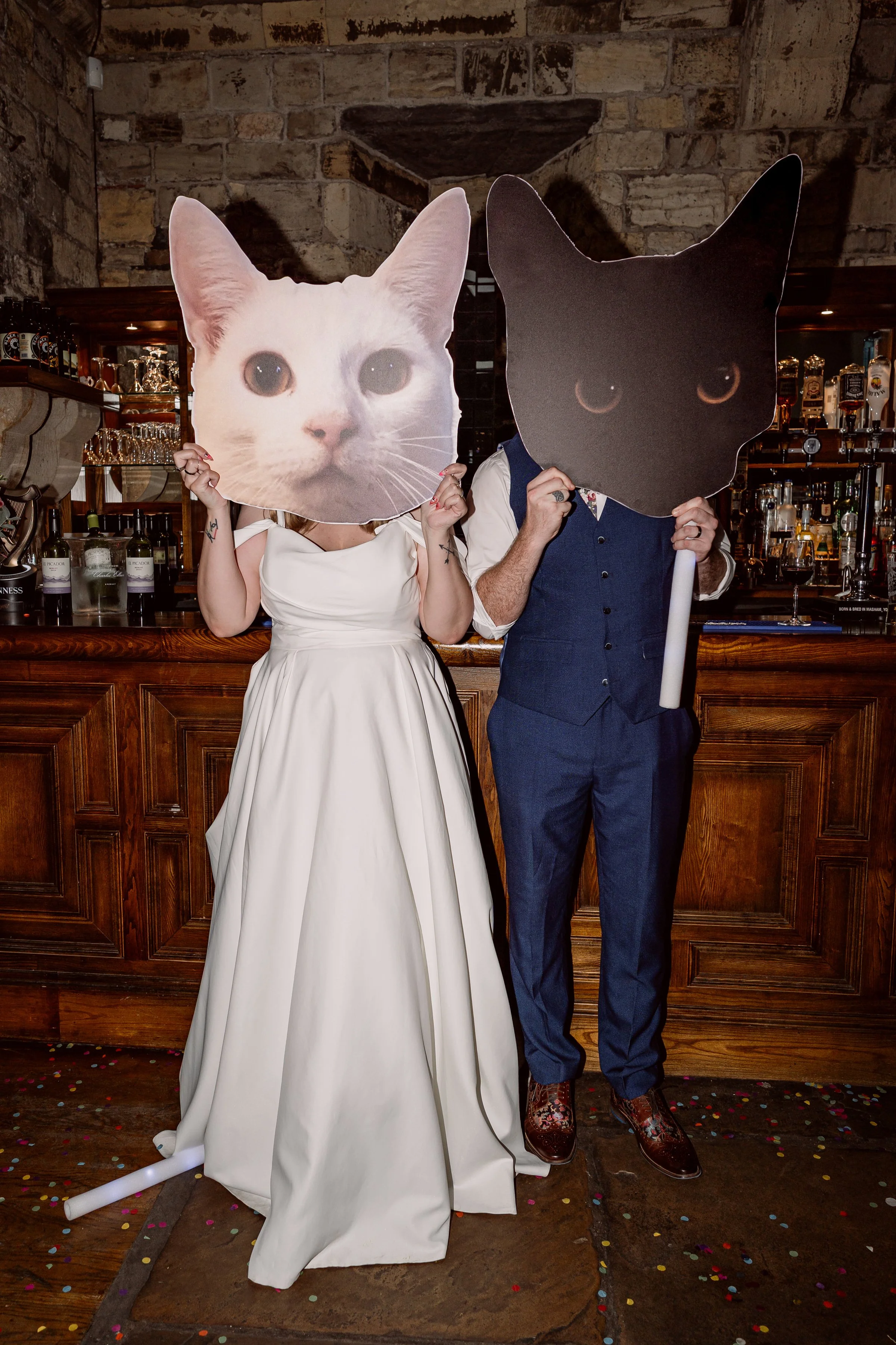 The bride and groom with giant cat masks at their non-traditional wedding