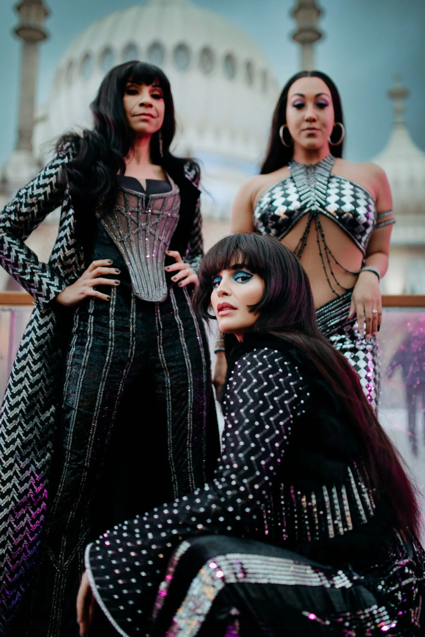 Photography of the three actresses playing Cher in The Cher Show in front of an ice rink at Brighton Pavilion