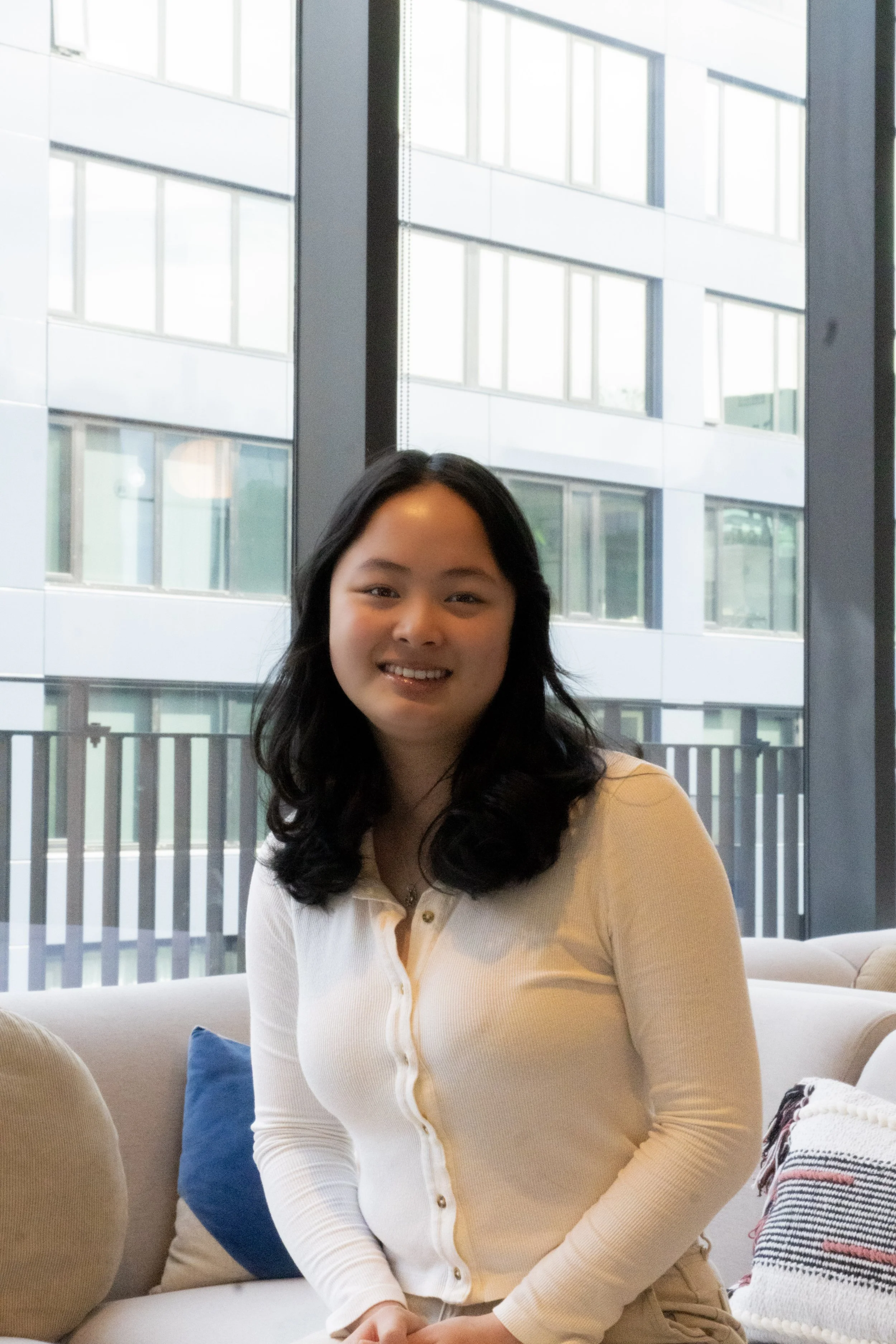 Maya seated in front of window