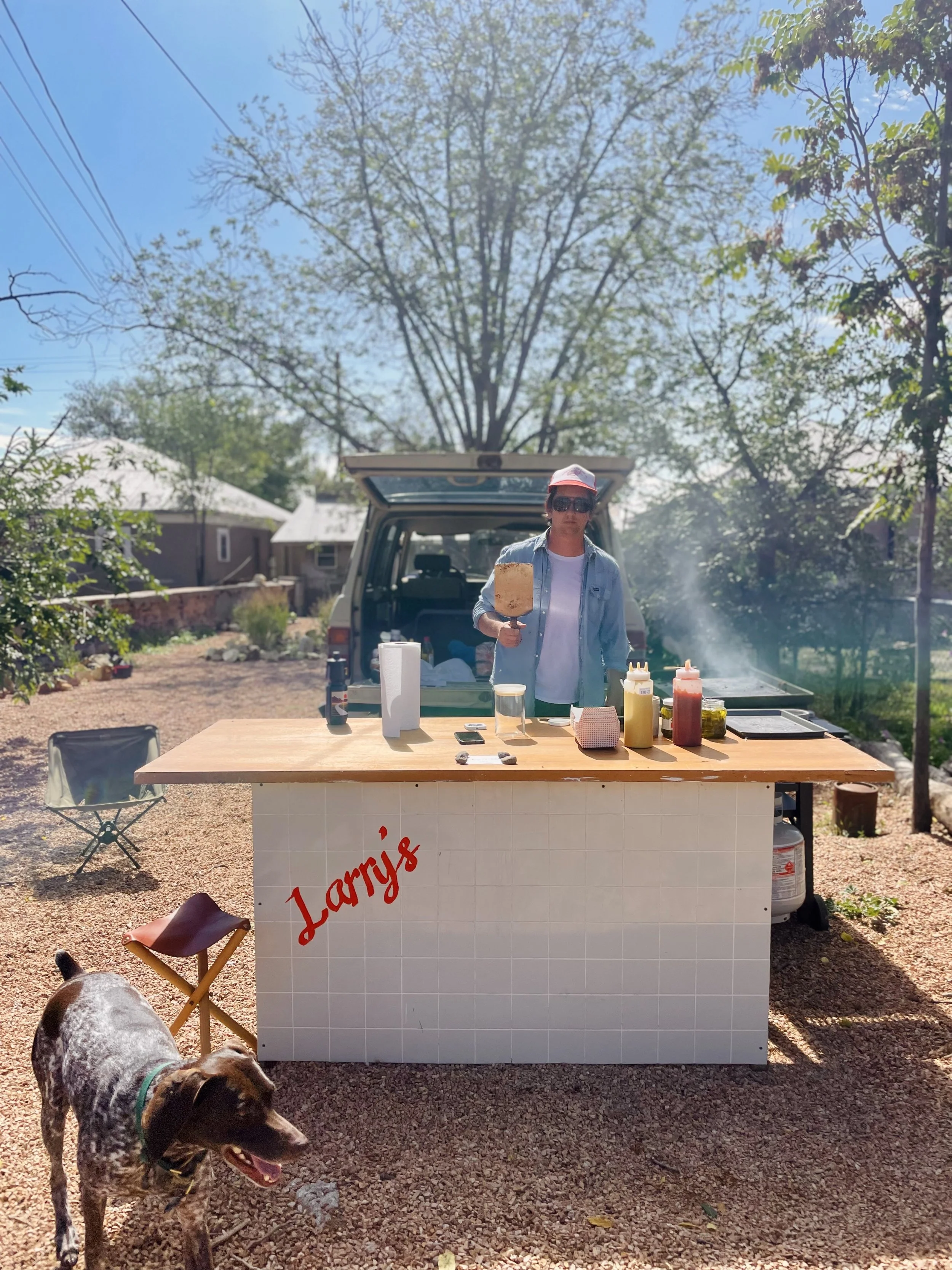 Larry's first-gen burger sign hand-painted on found paneling and door