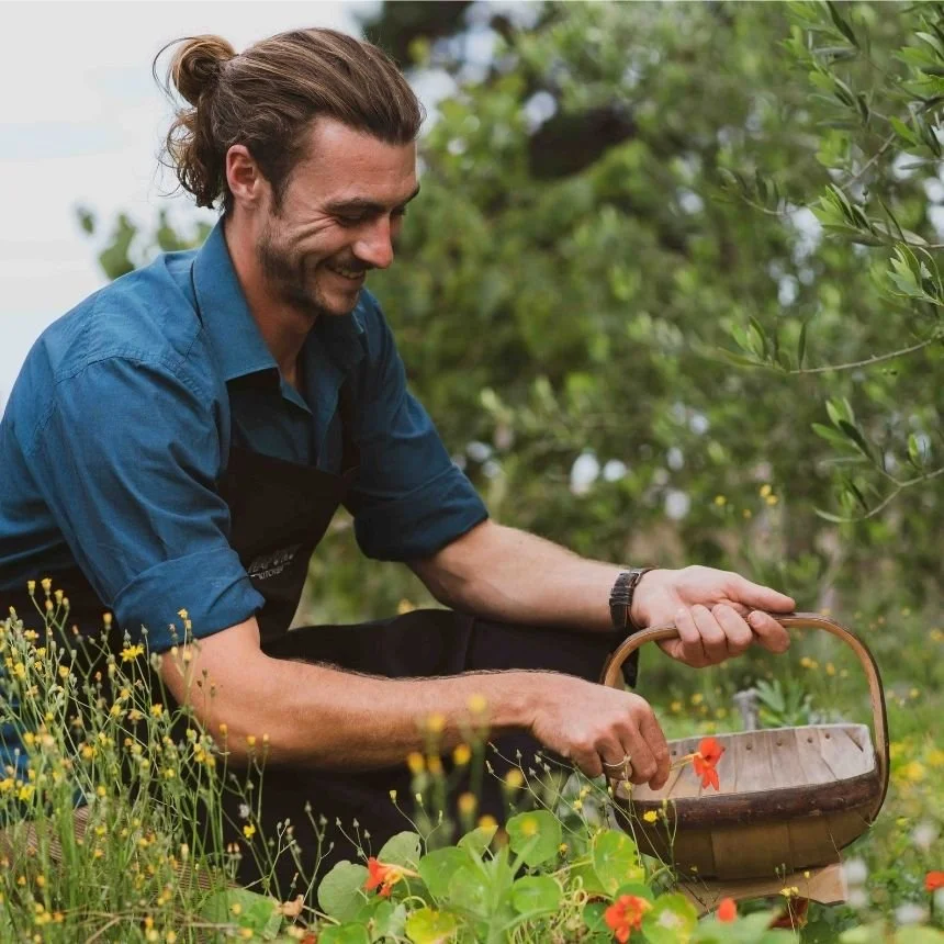 A guest a Hapuku Kitchen in Kaikōura picking fresh vegetables from the garden