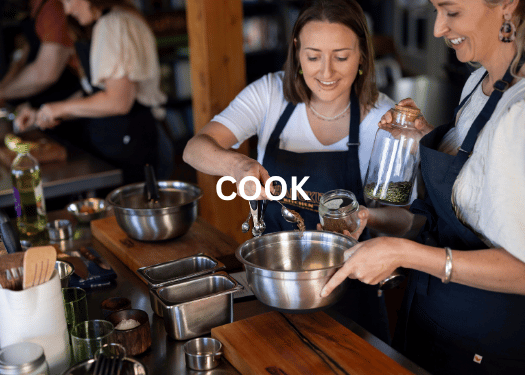 Guests enjoying a hands-on cooking class at Hapuku Kitchen, New Zealand
