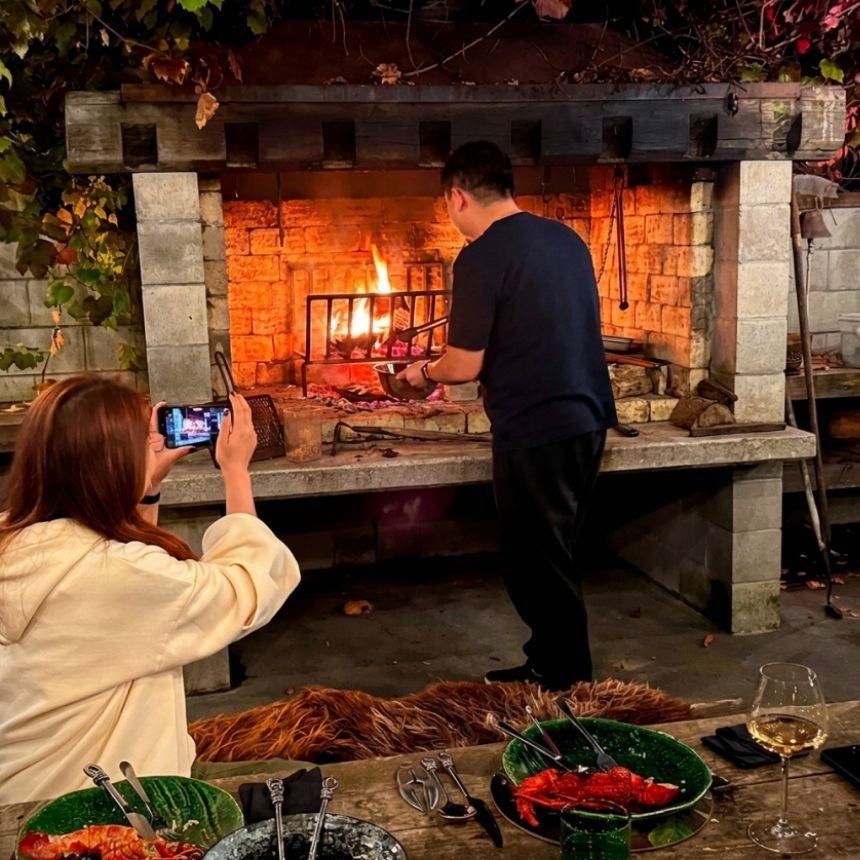Guests at Hapuku Kitchen Cooking School, chargrilling freshly harvested vegetables over fire
