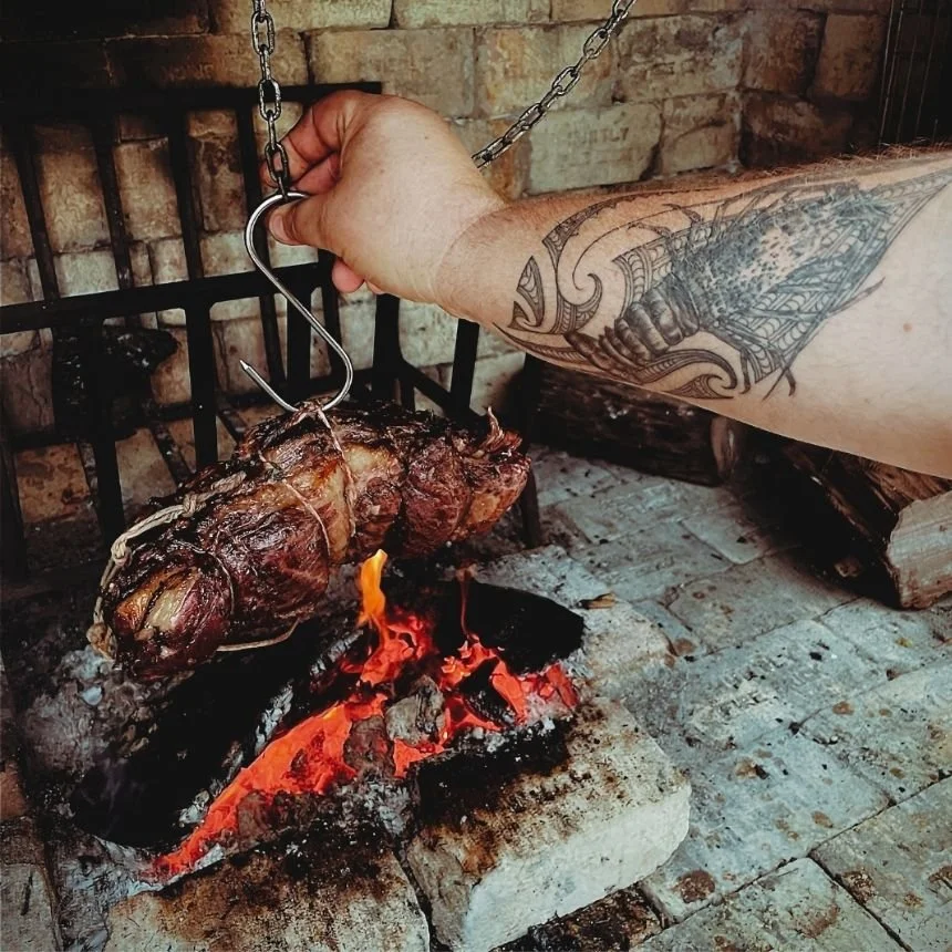Rolled home-grown beef roasting over coals at Hapuku Kitchen Cooking School, Kaikōura