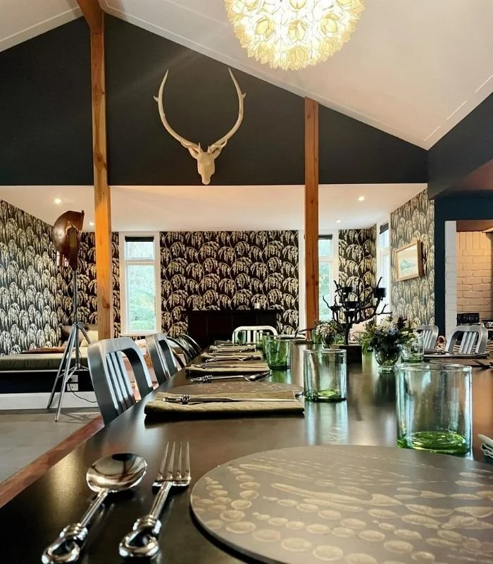 A view from the main dining table to the fireside nook at Hapuku Kitchen Cooking School, New Zealand