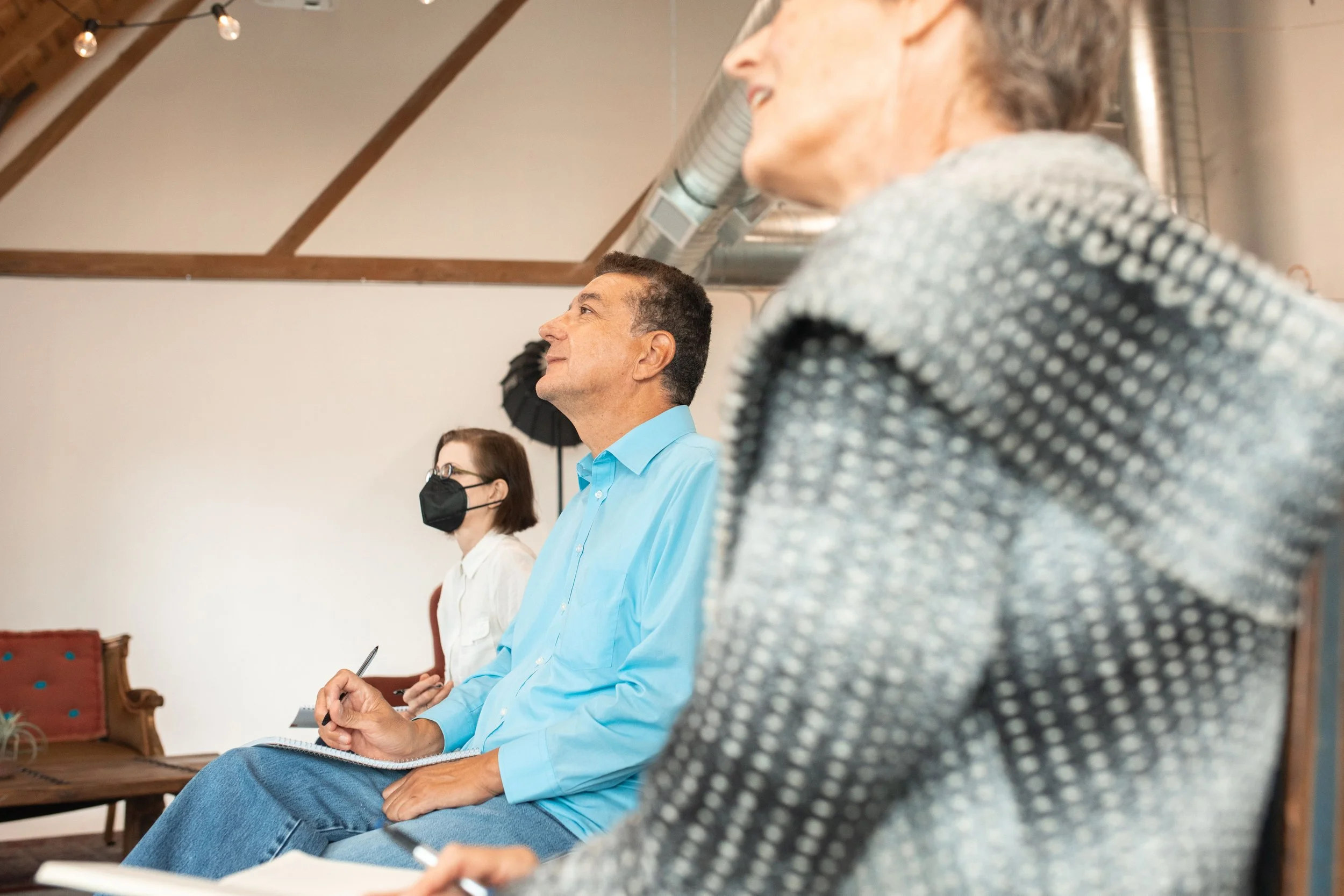three people sitting taking notes listening public meeting
