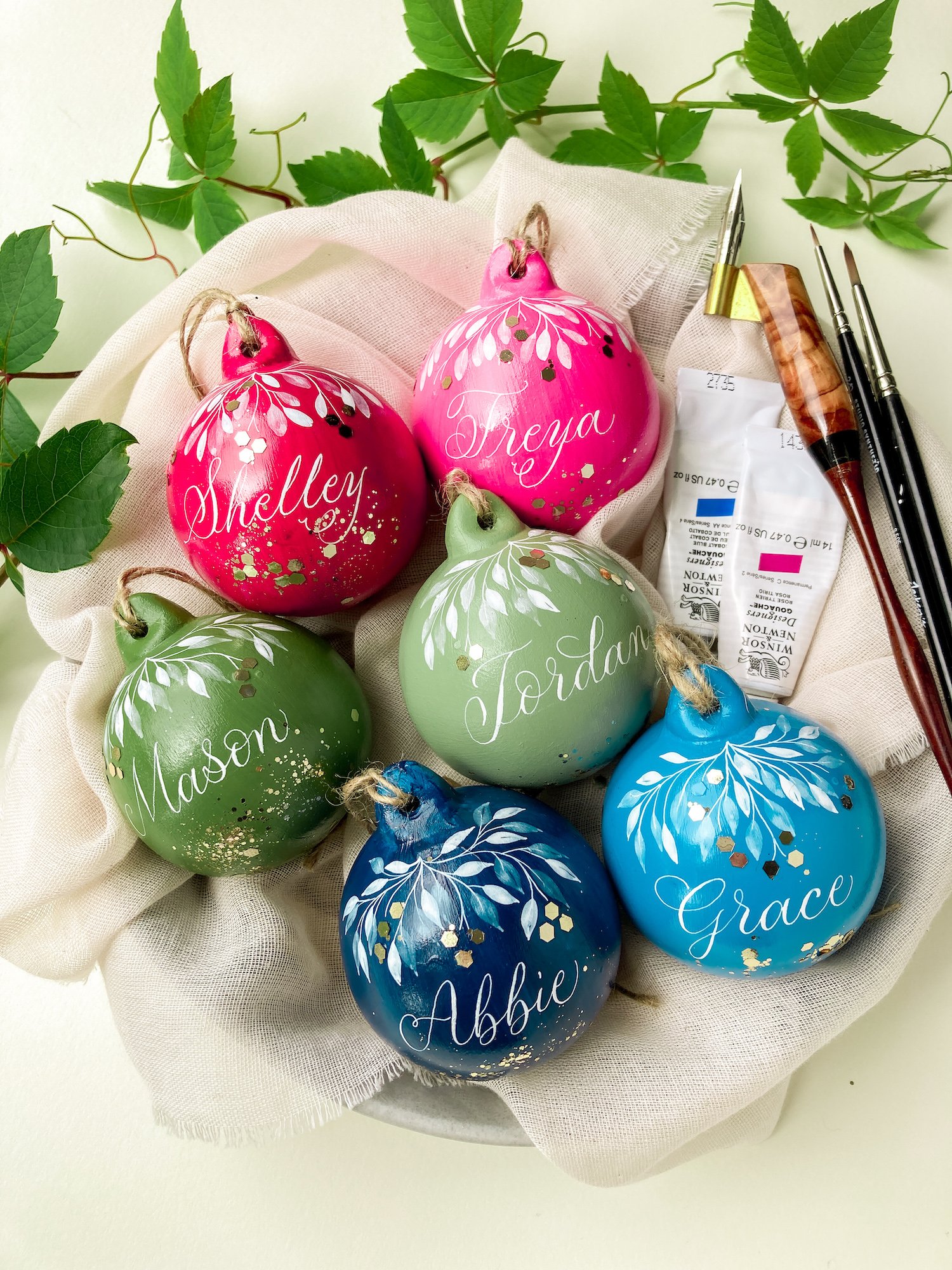 Personalised Christmas bauble in bright colours with glitter and calligraphy