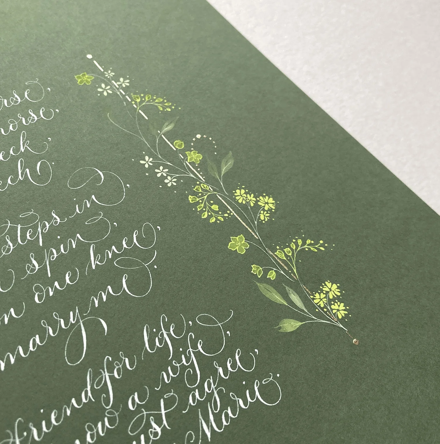 Calligraphy poem commission in white ink on green paper with floral border