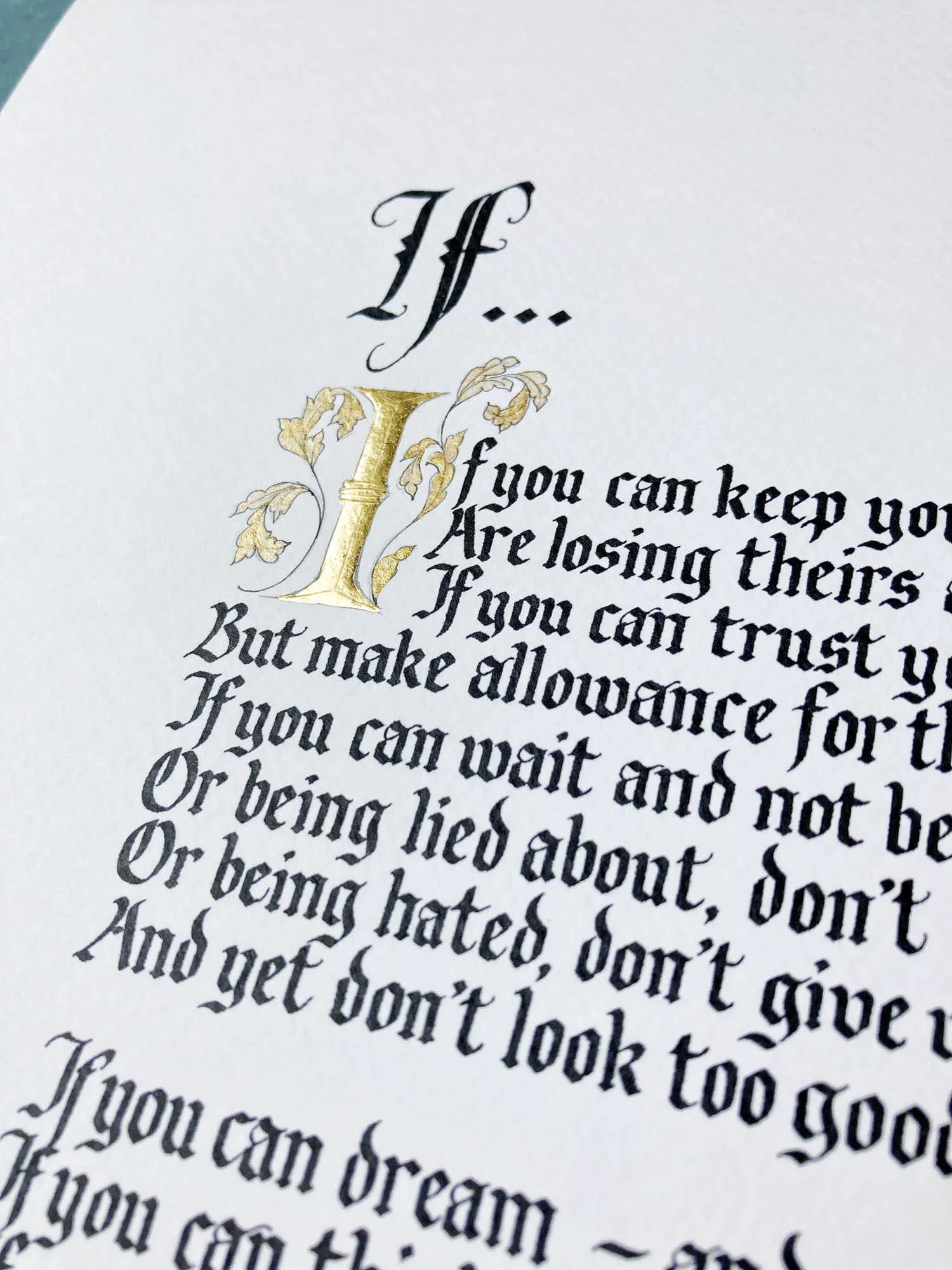 Rudyard Kipling's If poem in handwritten ornate blackletter calligraphy and a large gold decorative letter 'I' at the start, with some gold leaf accents. By Moon & Tide Calligraphy UK