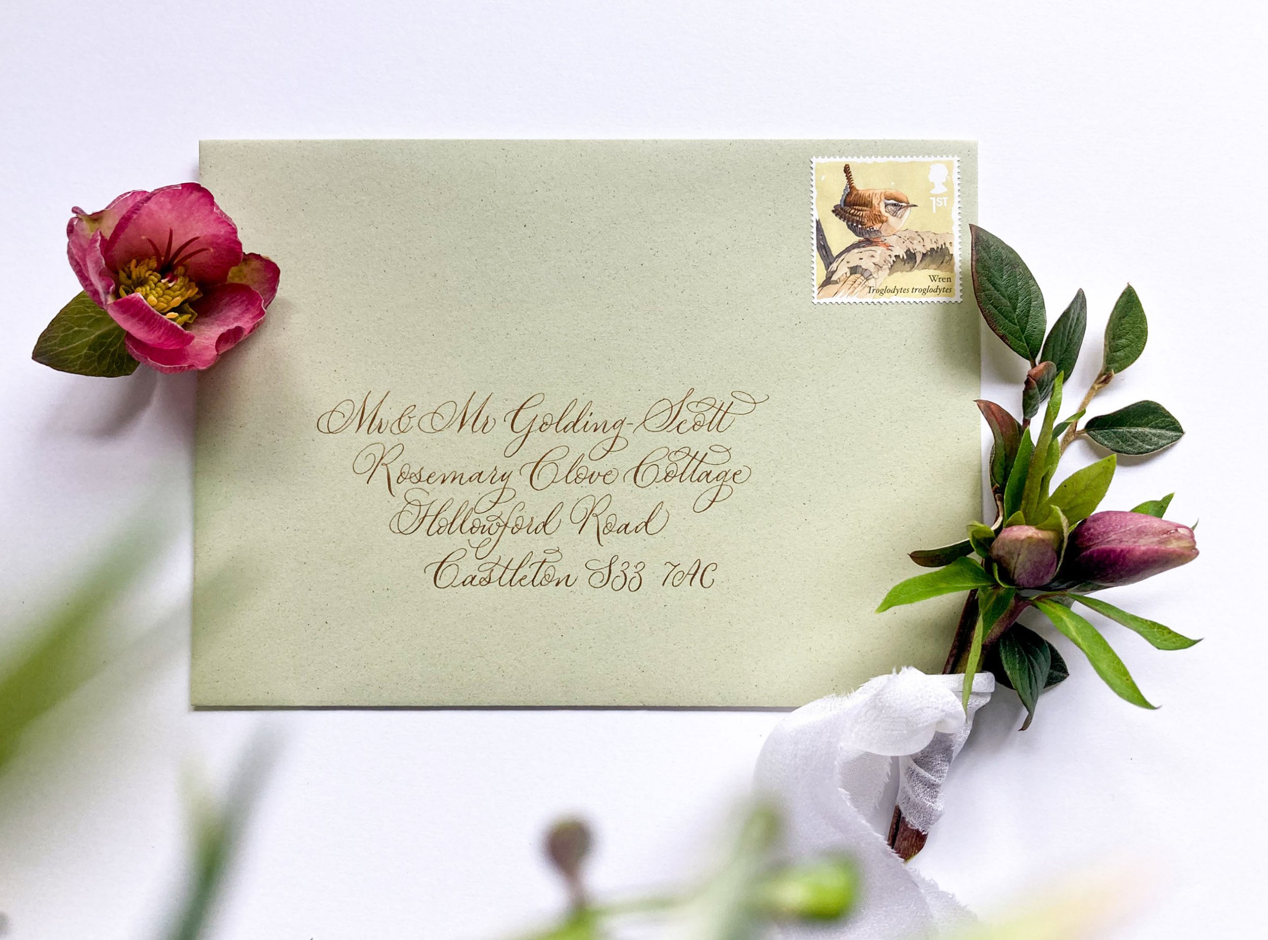 Calligraphy address on a pistachio green envelope written in a delicate modern style by Claire at By Moon and Tide