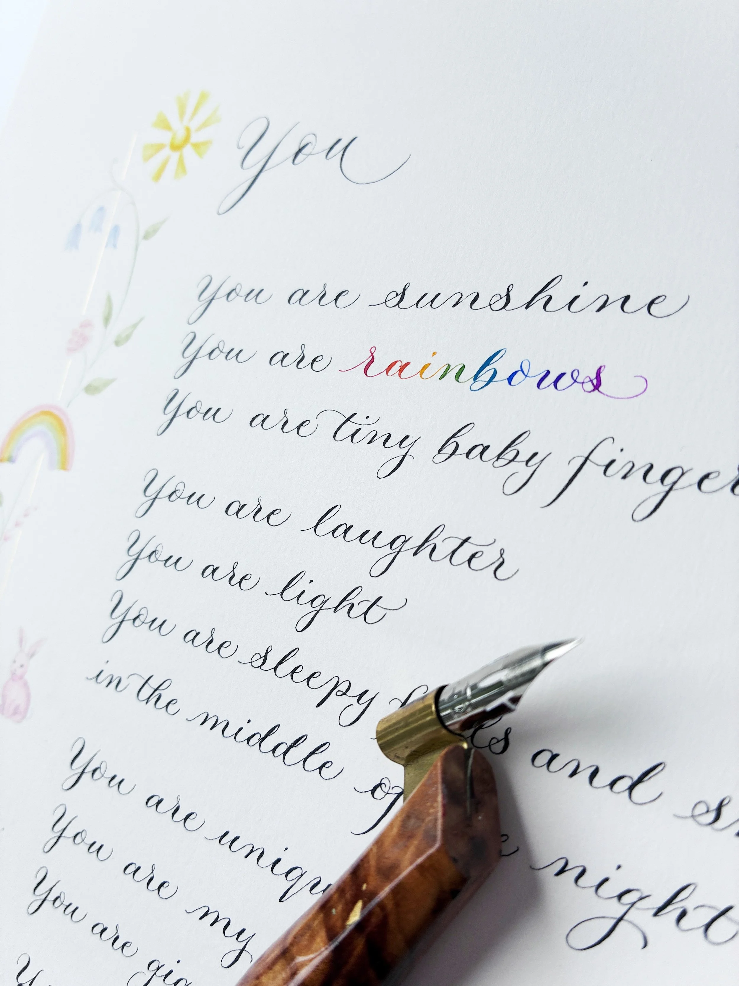 Close up of handwritten calligraphy poem titled You, with illustrations in the border